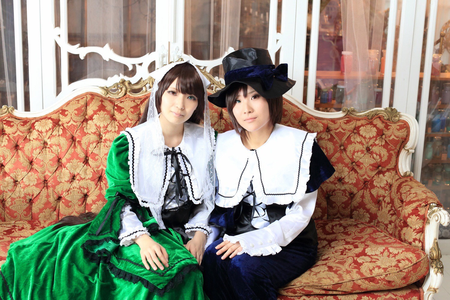 2girls 91076 bangs black_hair brown_hair couch curtains dress green_dress hat indoors lace long_hair long_sleeves looking_at_viewer multiple_cosplay multiple_girls ribbon sisters sitting tagme window