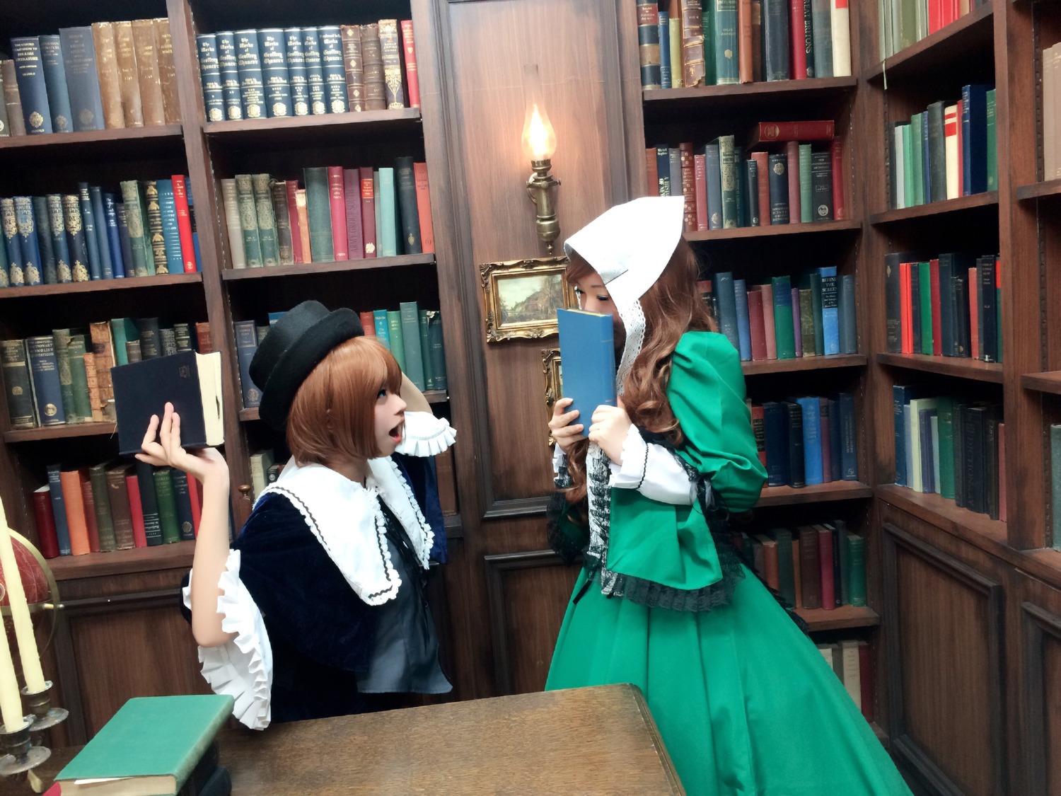 2girls blue_eyes book book_stack bookshelf brown_hair capelet dress hat holding_book library long_hair multiple_cosplay multiple_girls profile quill short_hair standing tagme voile