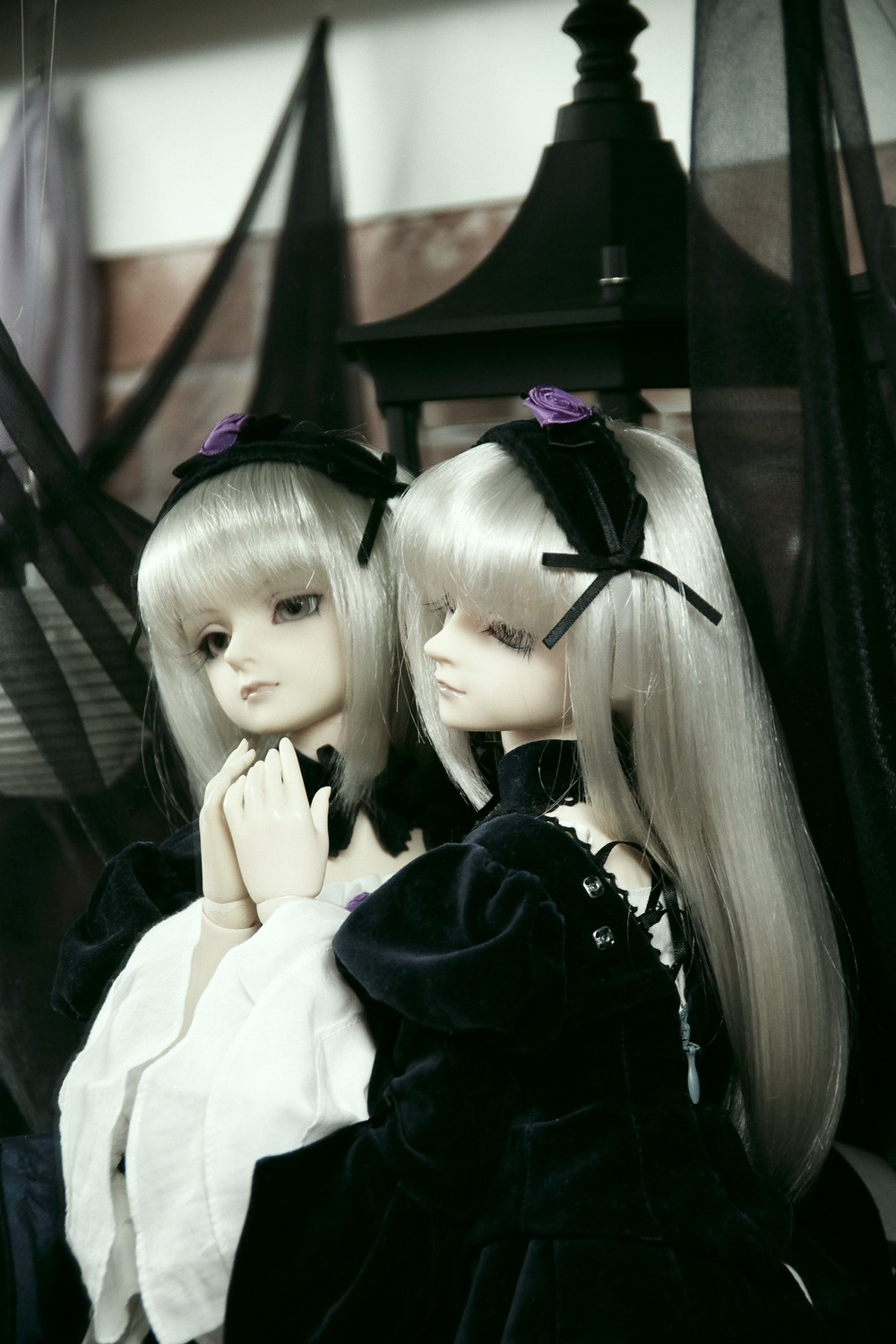 2girls bangs blurry depth_of_field doll dress frills gothic_lolita hair_ornament hairband lolita_fashion long_hair long_sleeves looking_at_viewer multiple_girls photo ribbon siblings sisters solo suigintou twins white_hair