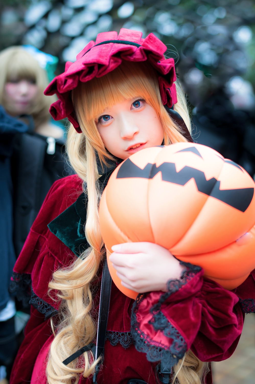 1girl blonde_hair blue_eyes blurry blurry_background blurry_foreground breasts depth_of_field dress gloves lips long_hair looking_at_viewer photo red_dress shinku solo solo_focus upper_body