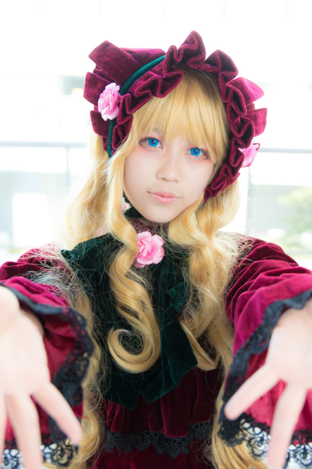 1girl bangs blonde_hair blue_eyes blurry blurry_background blurry_foreground bonnet depth_of_field flower foreshortening frills lips long_hair looking_at_viewer outstretched_arm outstretched_hand reaching reaching_out rose shinku solo