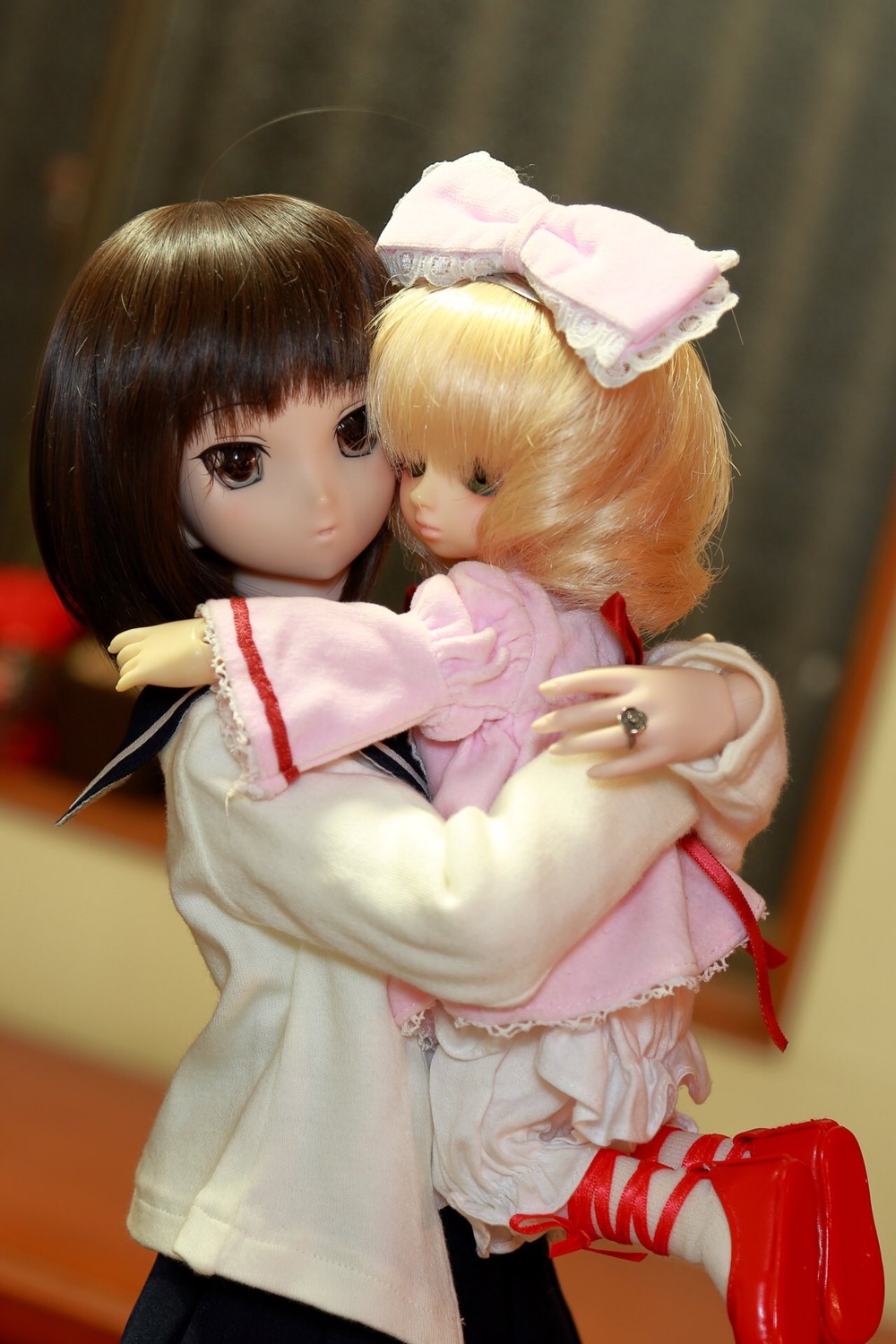 2girls black_hair blonde_hair blurry brown_eyes depth_of_field doll frills hinaichigo hug jewelry kashiwaba_tomoe long_sleeves multiple_girls ring short_hair solo