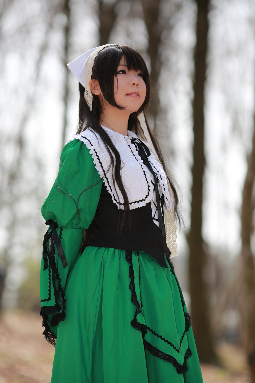 1girl black_hair blurry blurry_background closed_eyes depth_of_field dress green_dress lips long_sleeves outdoors solo standing suiseiseki