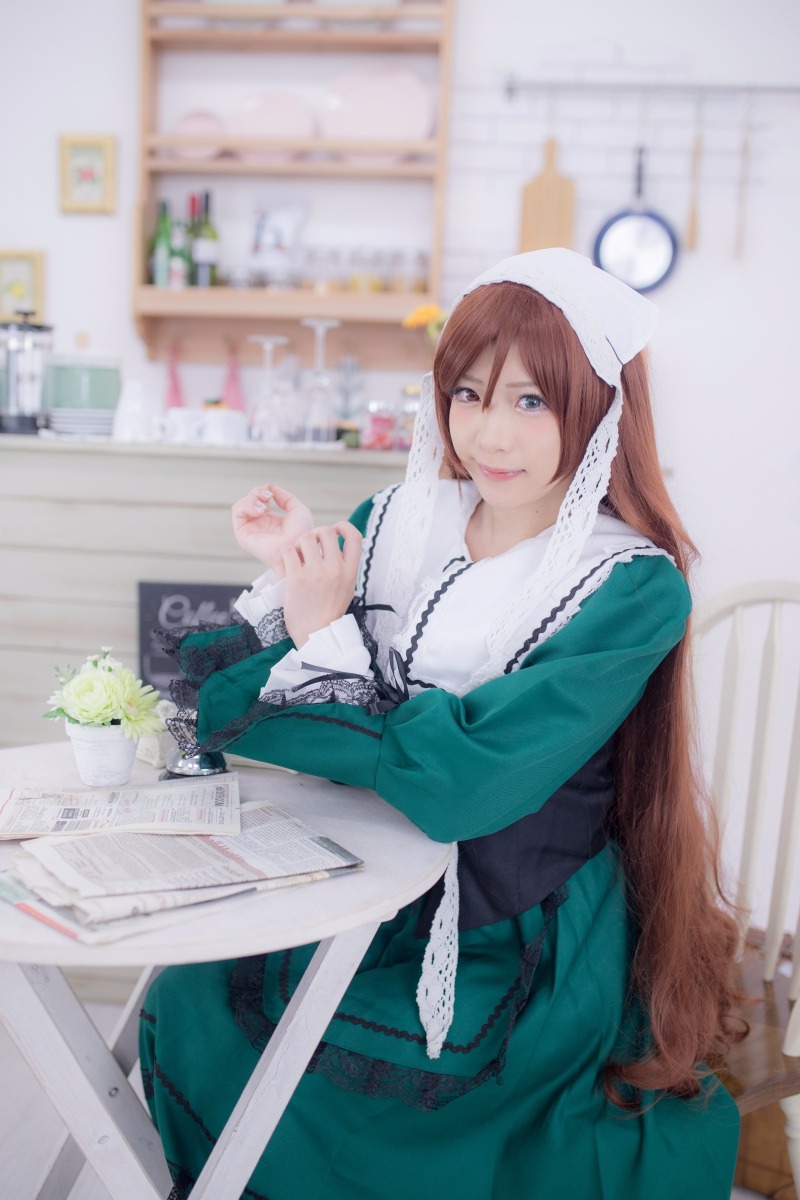 1girl apron blue_eyes blurry blurry_background blurry_foreground brown_hair depth_of_field dress green_dress head_scarf indoors lips long_hair looking_at_viewer photo sitting solo suiseiseki very_long_hair