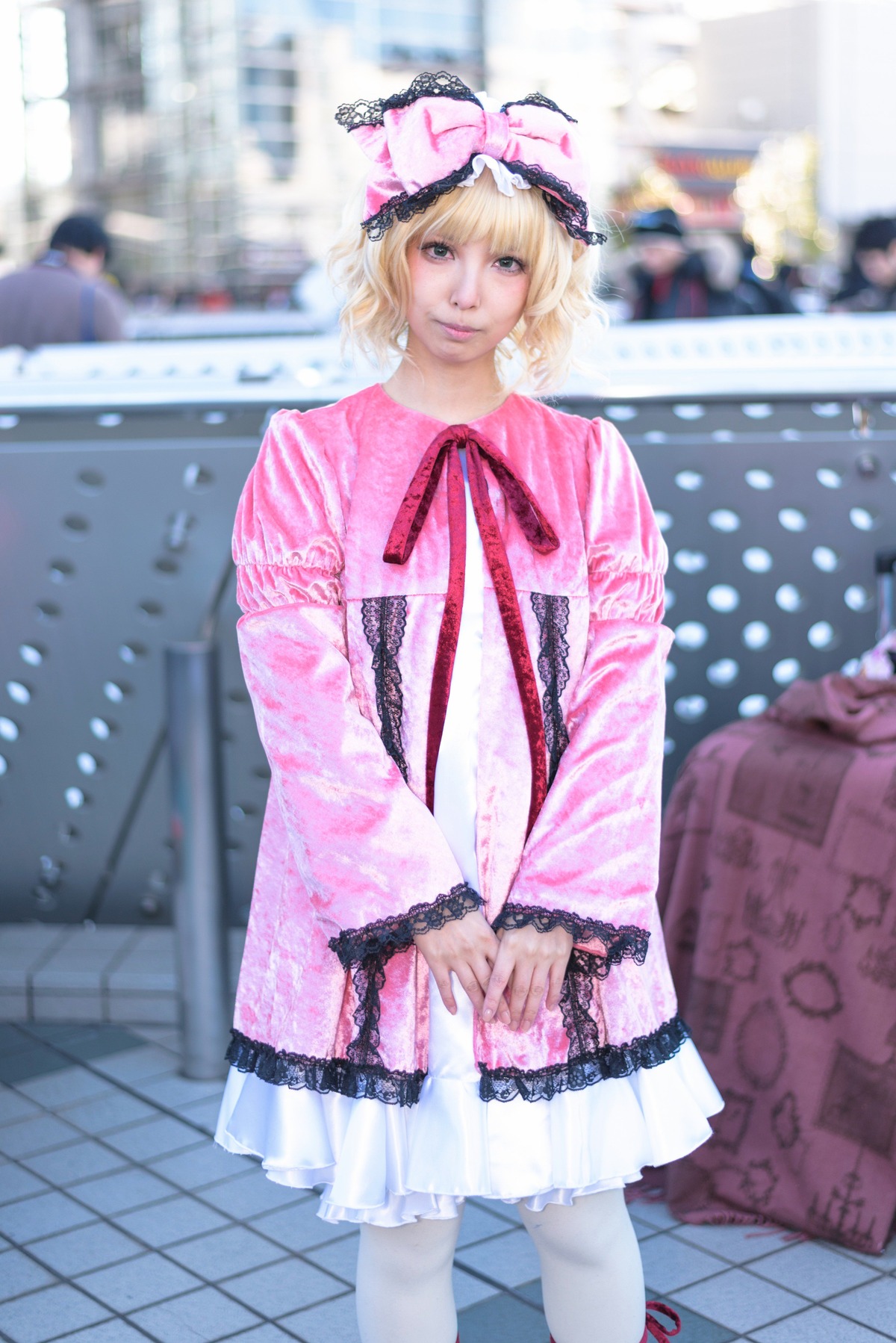 1girl blonde_hair blurry blurry_background building city depth_of_field dress frills hat hinaichigo long_sleeves looking_at_viewer outdoors photo realistic ribbon short_hair smile solo standing wide_sleeves