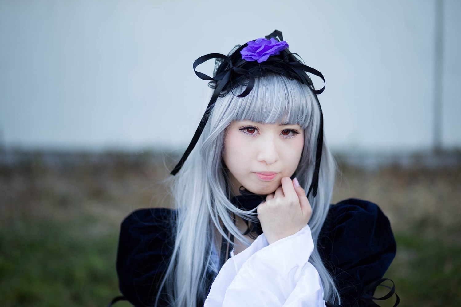 1girl bangs blunt_bangs blurry blurry_background closed_mouth depth_of_field dress flower hair_flower hair_ornament lips long_hair long_sleeves looking_at_viewer red_eyes ribbon solo suigintou upper_body