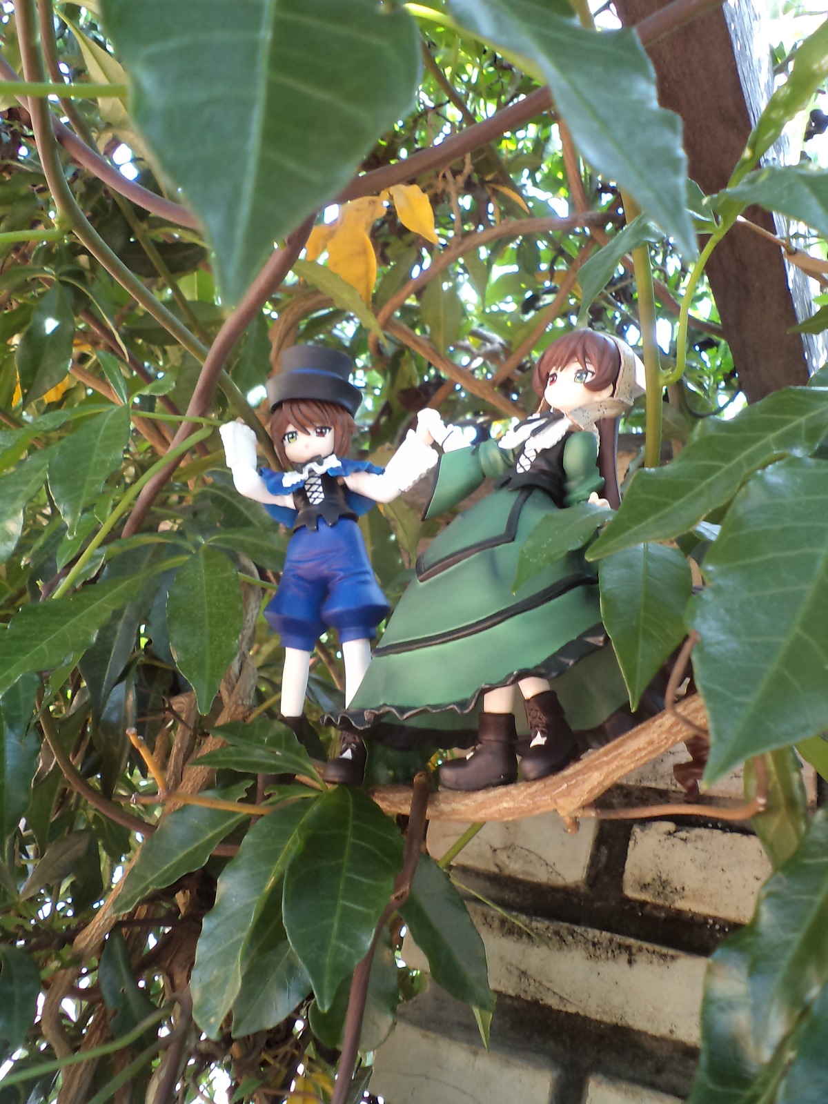 1boy 1girl blue_dress boots brown_footwear brown_hair capelet doll dress gloves green_eyes hat long_hair long_sleeves multiple_dolls outdoors pants siblings standing tagme tree