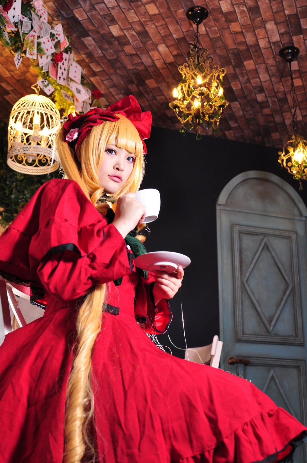 1girl blonde_hair blue_eyes bow clock cup dress flower hair_bow indoors lips looking_at_viewer realistic red_dress shinku sitting solo teacup