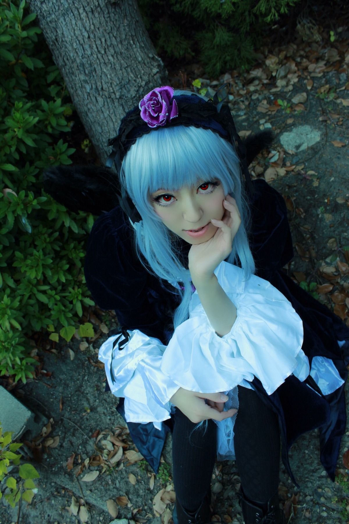 1girl bangs bonnet closed_mouth dress flower frills gothic_lolita hood lips long_hair long_sleeves looking_at_viewer nail_polish nature outdoors plant red_eyes sitting smile solo suigintou water