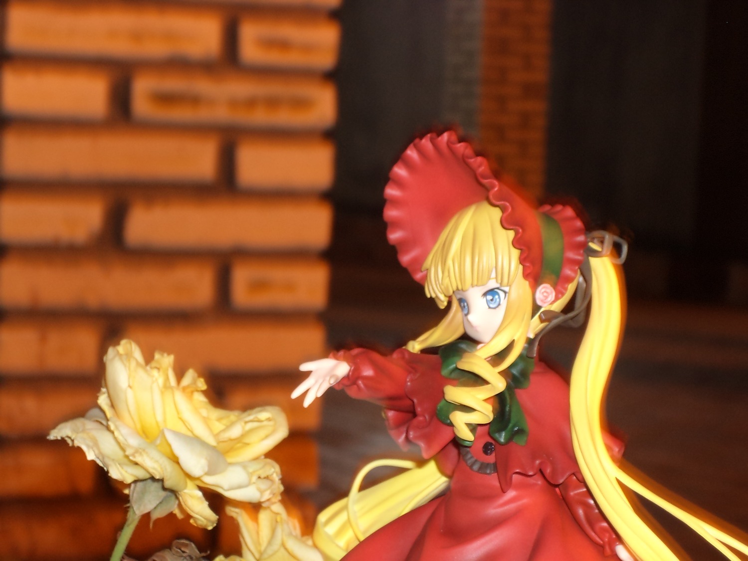 1girl blonde_hair blue_eyes blurry bonnet bow depth_of_field doll dress long_hair long_sleeves outstretched_arm red_dress shinku solo twintails very_long_hair