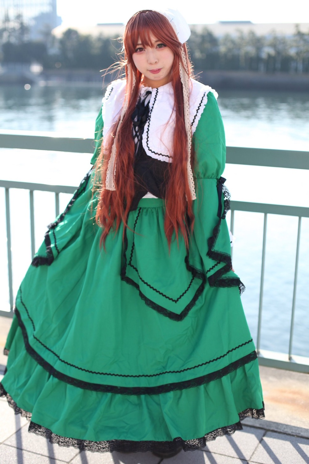 1girl blurry breasts brown_hair day dress green_dress long_hair looking_at_viewer outdoors smile solo suiseiseki tile_floor