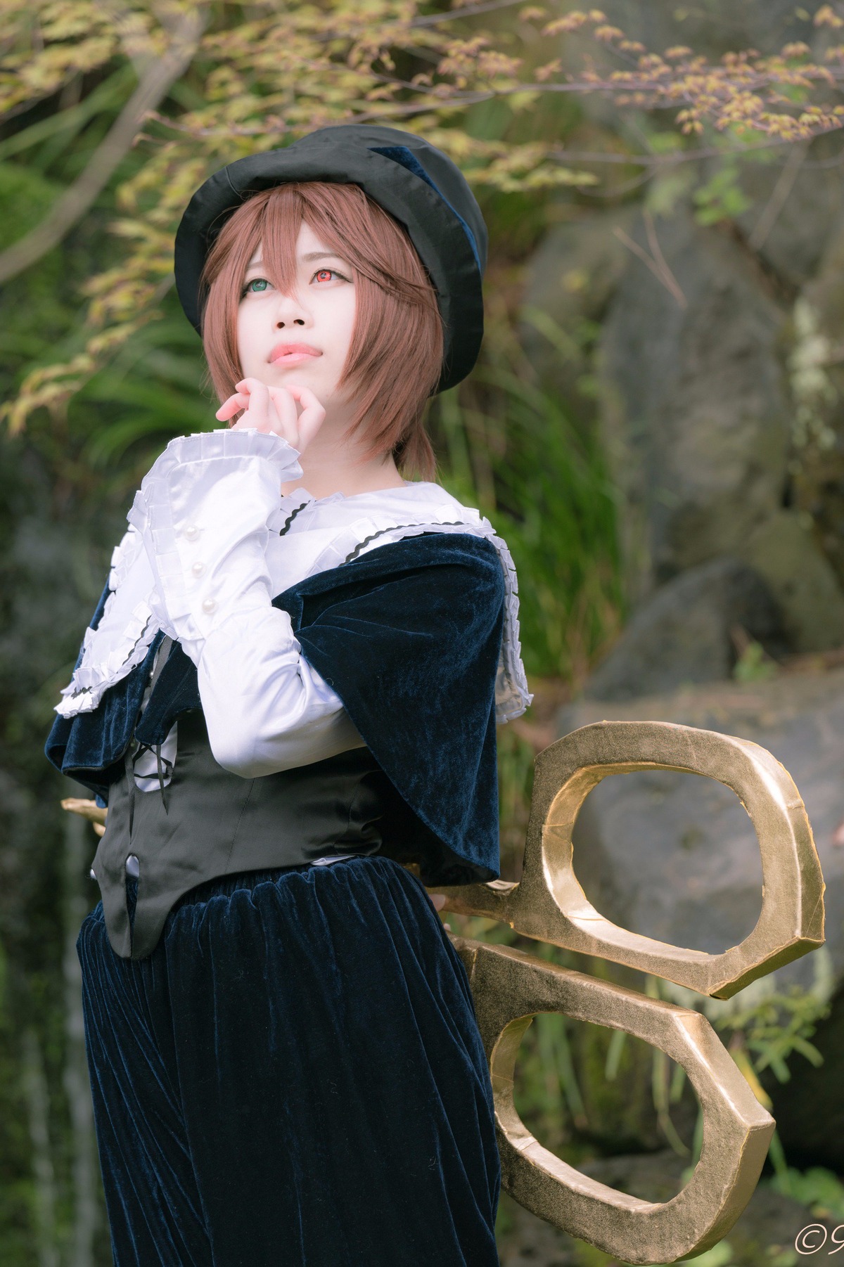 1girl blurry blurry_background brown_hair capelet depth_of_field hat lips long_sleeves outdoors red_eyes short_hair skirt solo souseiseki