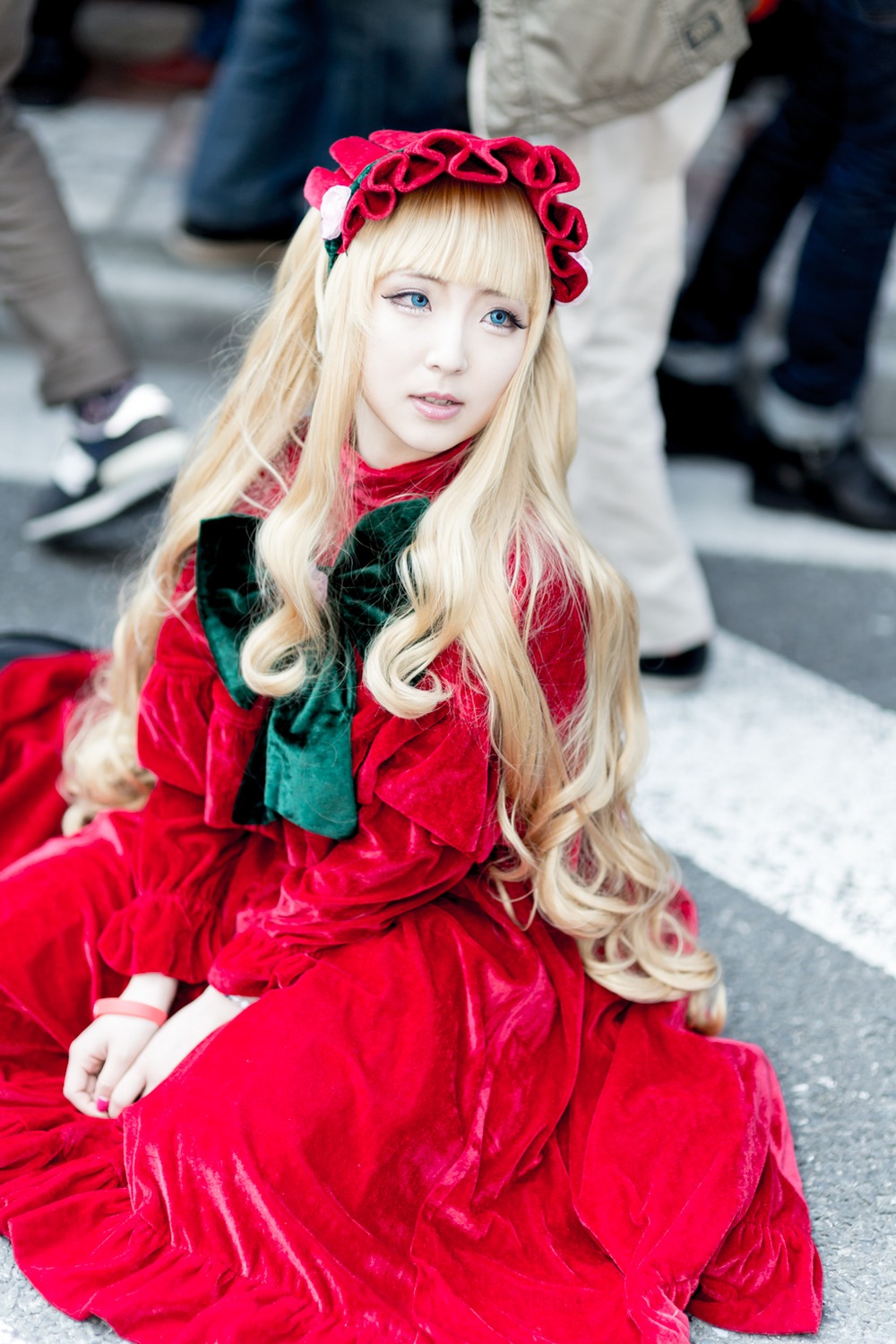 1girl blonde_hair blue_eyes blurry blurry_background blurry_foreground depth_of_field dress lips long_hair long_sleeves looking_at_viewer photo red_dress shinku sitting solo solo_focus