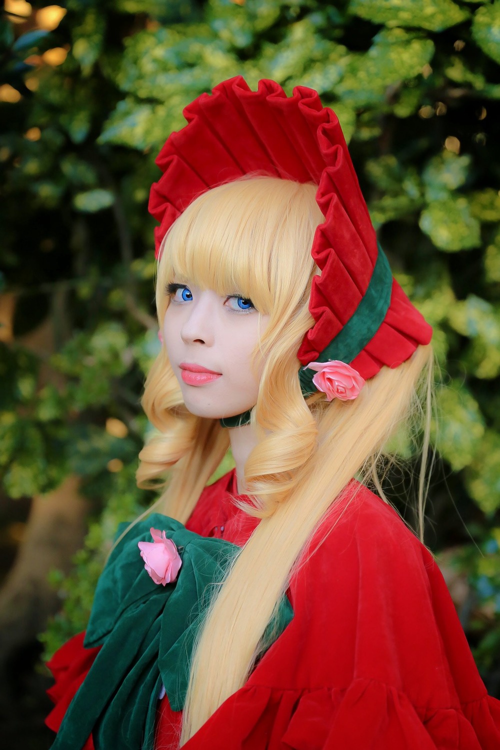 1girl bangs blonde_hair blue_eyes blurry blurry_background bonnet bow depth_of_field drill_hair flower lips long_hair looking_at_viewer shinku solo upper_body