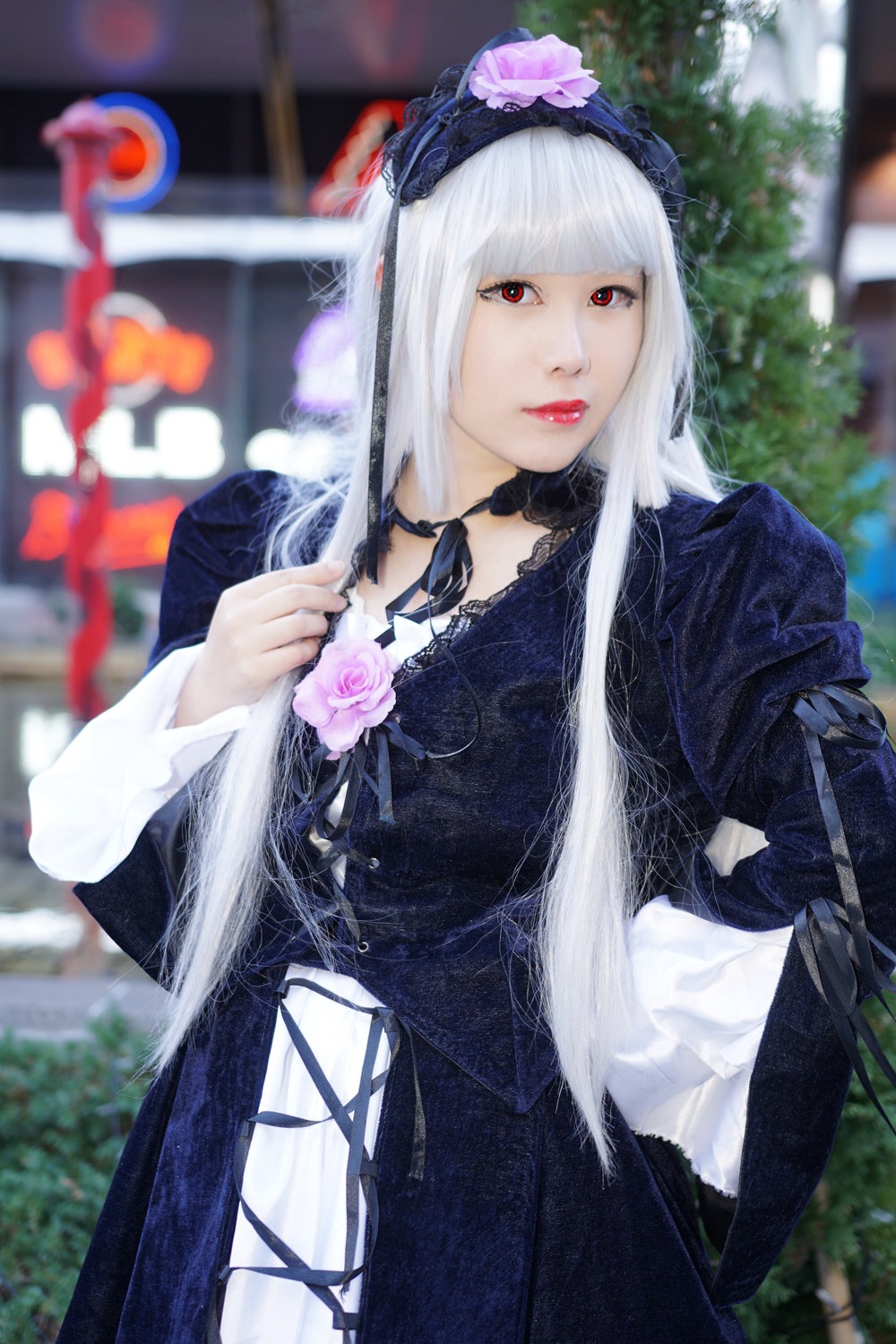 1girl bangs black_dress blurry blurry_background blurry_foreground depth_of_field dress flower gothic_lolita hairband lips lolita_fashion long_hair long_sleeves looking_at_viewer photo red_eyes rose solo suigintou white_hair