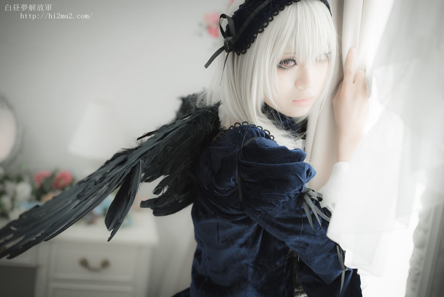 1girl black_dress black_wings blurry blurry_background blurry_foreground closed_mouth depth_of_field dress flower hairband lips long_sleeves looking_at_viewer photo ribbon silver_hair solo suigintou upper_body wings