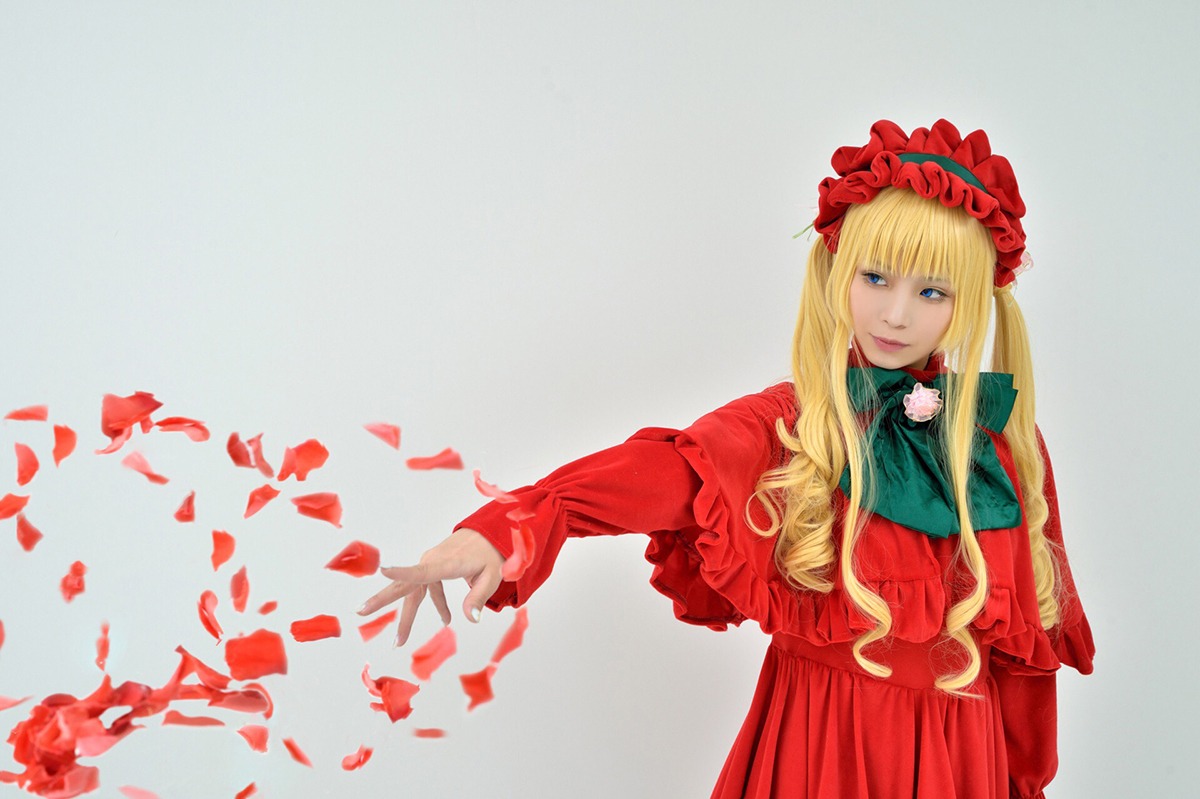 1girl blonde_hair blue_eyes bonnet capelet dress flower green_neckwear long_hair long_sleeves looking_at_viewer outstretched_arm petals red_capelet red_dress rose shinku solo