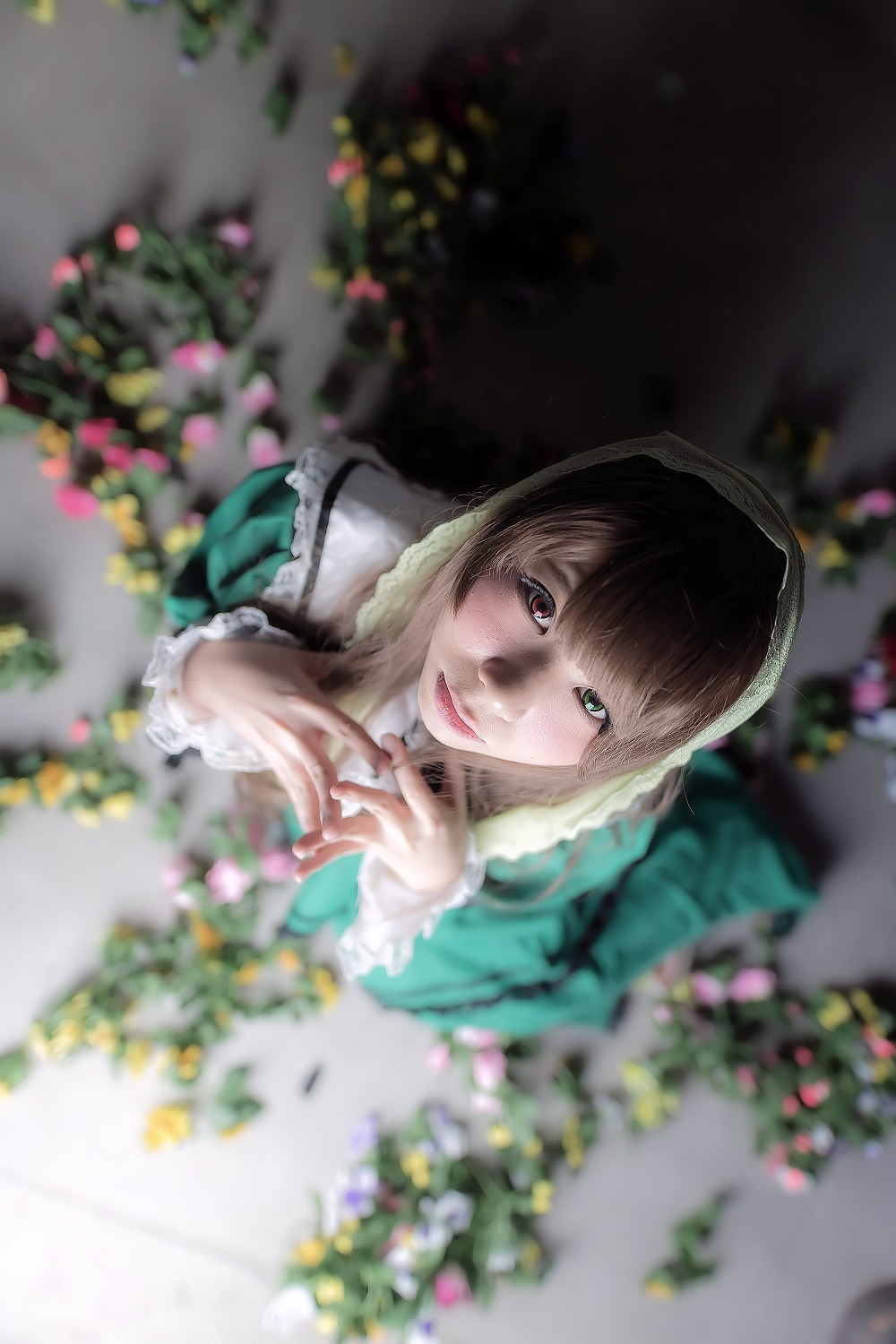 1girl 3d blurry blurry_background blurry_foreground brown_hair chromatic_aberration closed_mouth depth_of_field flower green_eyes heterochromia hood lips looking_at_viewer motion_blur photo plant red_eyes solo suiseiseki