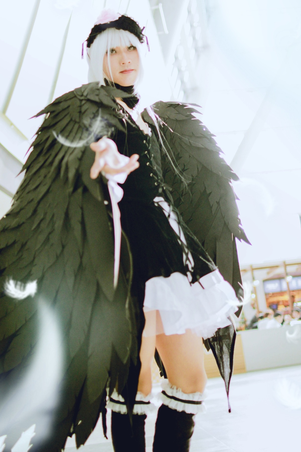 1girl black_wings blurry depth_of_field dress feathers frills solo standing suigintou white_hair wings