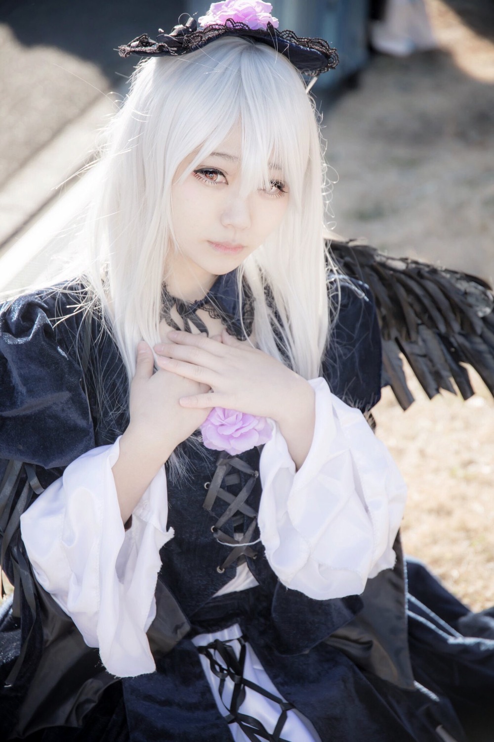 1girl blurry blurry_background blurry_foreground closed_mouth corset depth_of_field dress gothic_lolita hands_together lolita_fashion long_hair long_sleeves nail_polish own_hands_together photo ribbon solo suigintou white_hair wings