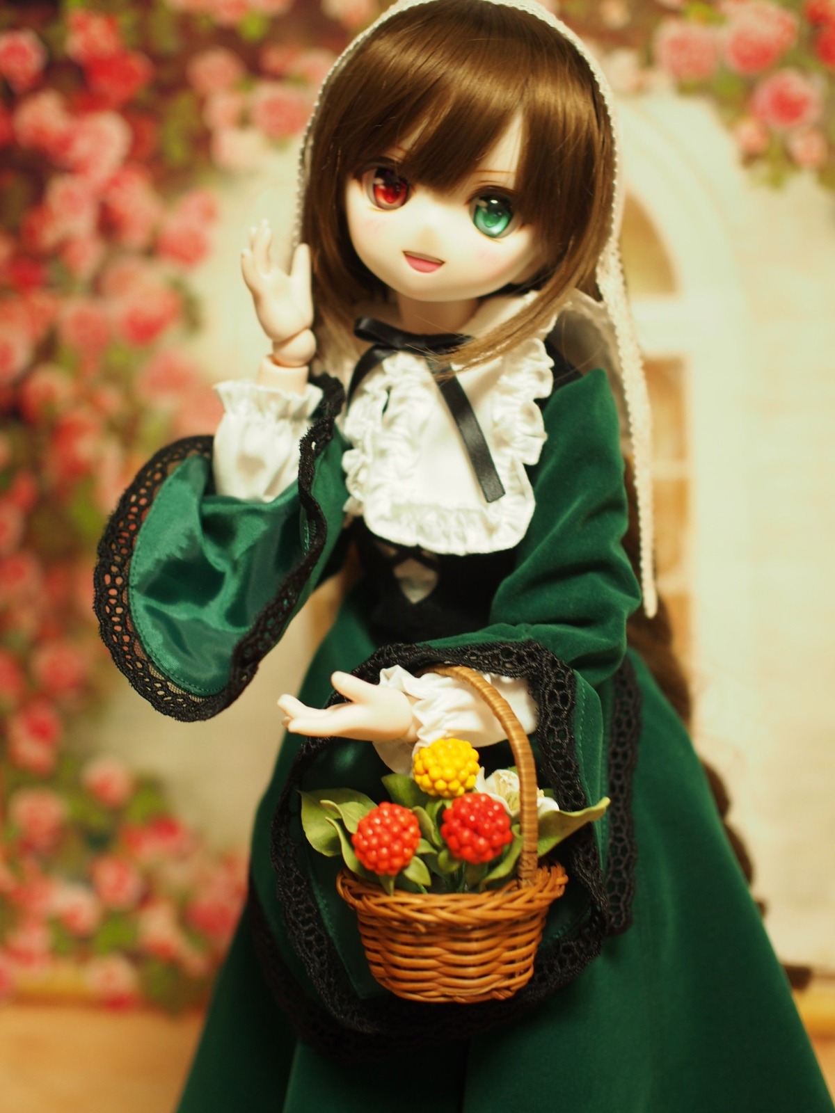 1girl :d bangs basket blurry blurry_background blurry_foreground brown_hair depth_of_field dress flower food fruit grapes green_dress green_eyes heterochromia long_hair long_sleeves looking_at_viewer open_mouth photo red_eyes smile solo standing suiseiseki