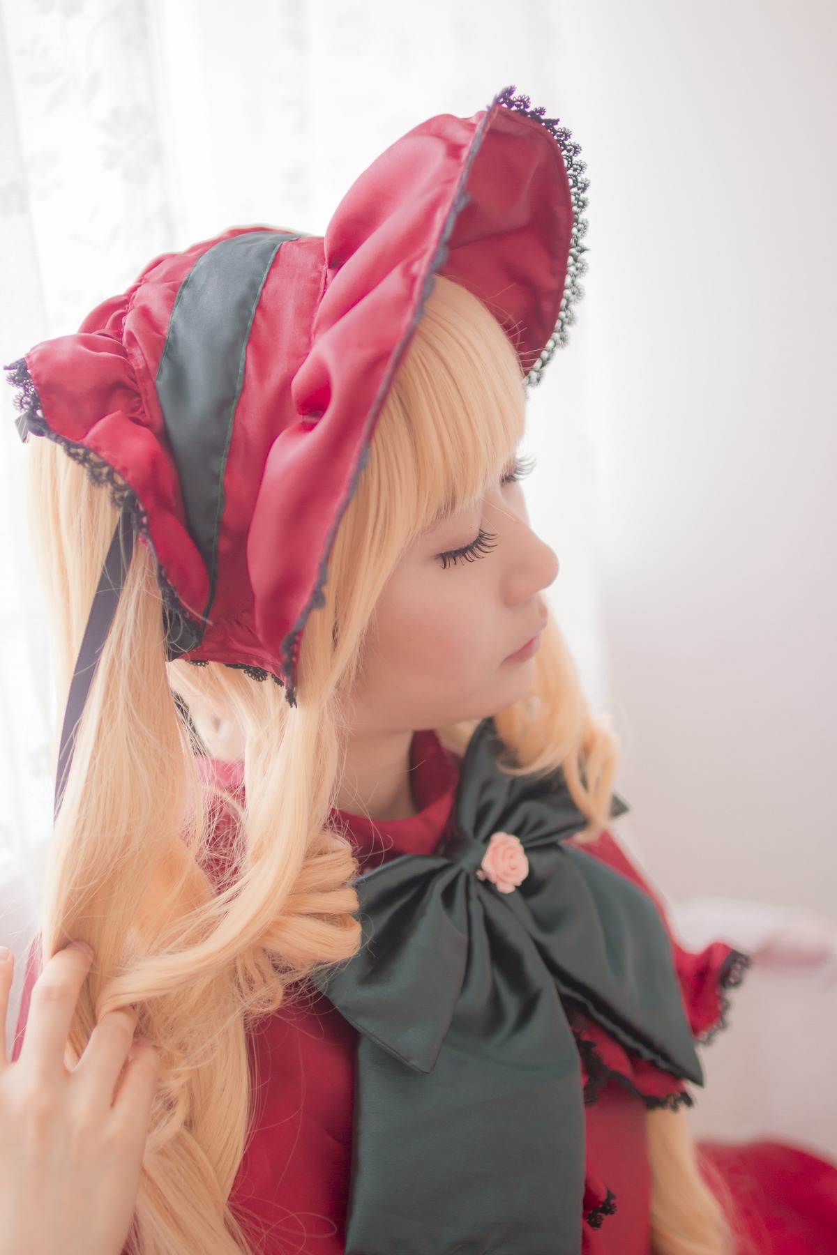 1girl bangs blonde_hair blurry bonnet bow bowtie closed_eyes depth_of_field dress long_hair profile red_dress ribbon shinku solo