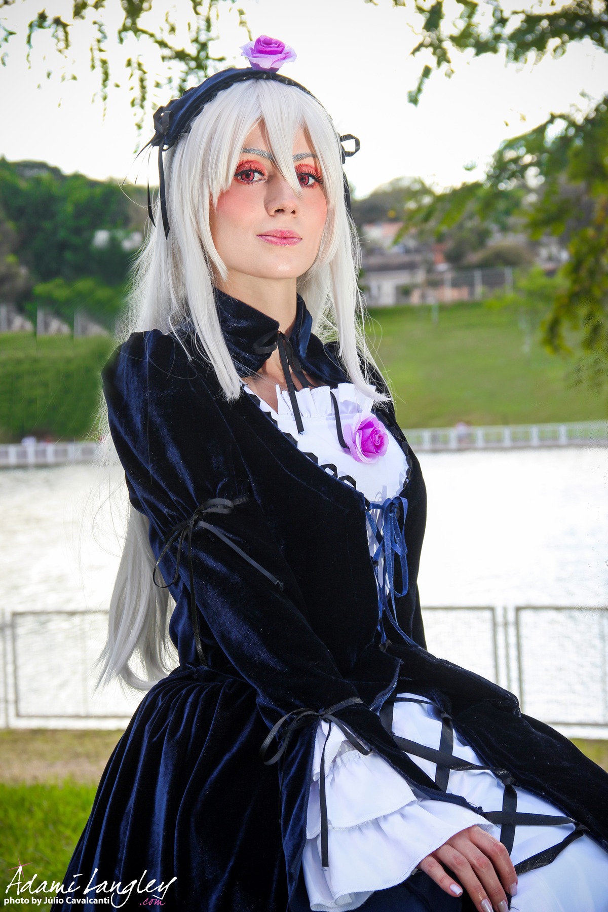 1girl black_dress blurry depth_of_field dress lips long_hair looking_at_viewer outdoors red_eyes signature solo suigintou