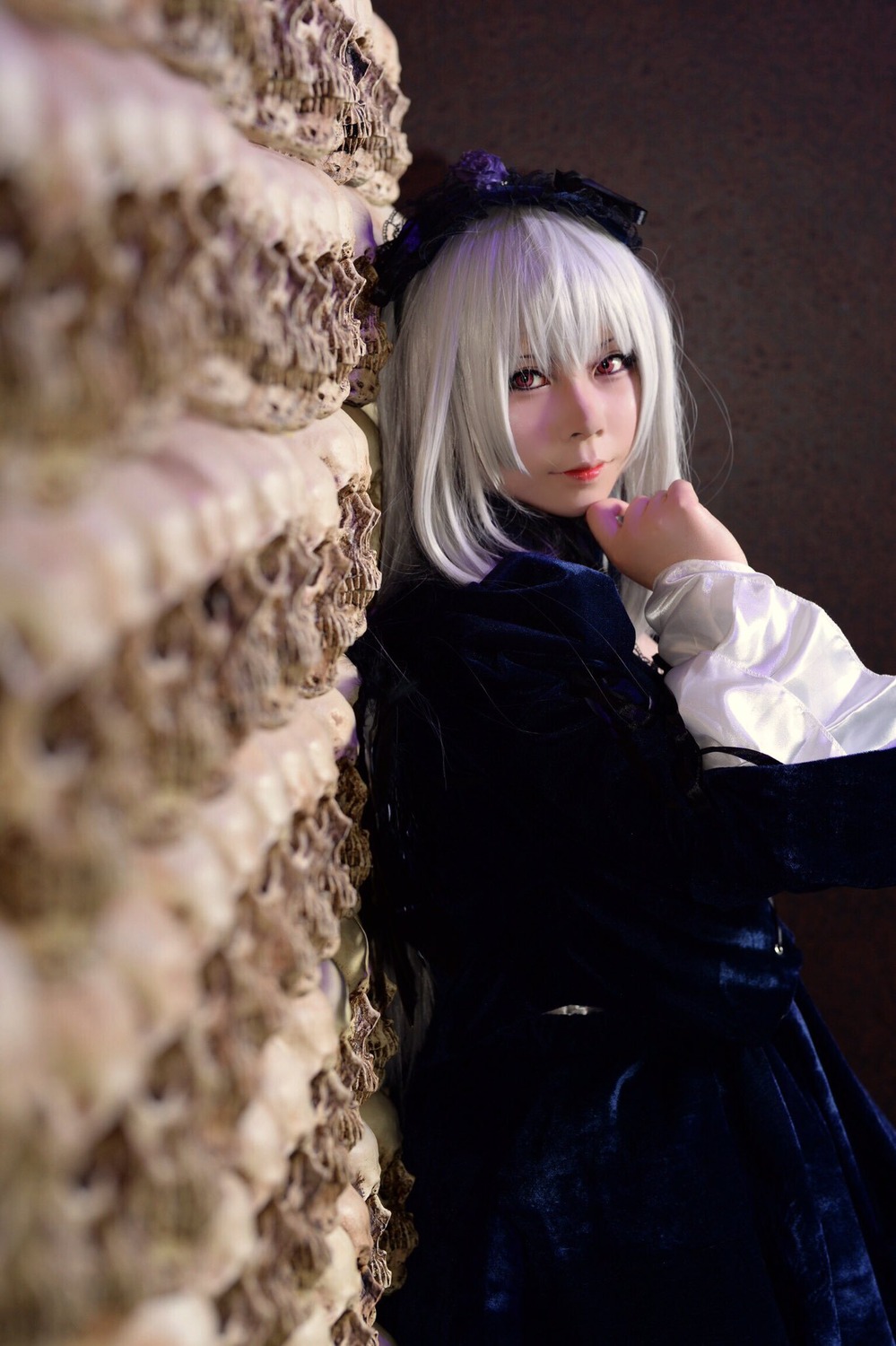 1girl bangs black_dress blurry blurry_background blurry_foreground closed_mouth depth_of_field dress flower lips long_hair long_sleeves looking_at_viewer nail_polish red_eyes solo suigintou