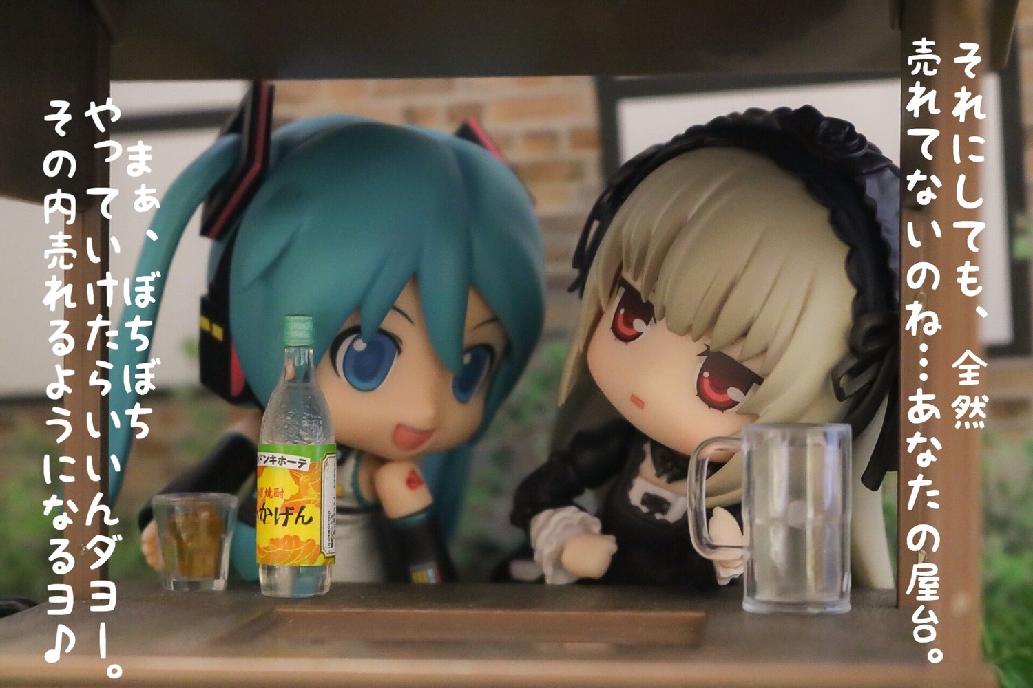 2girls blonde_hair blurry blurry_foreground chibi crossover depth_of_field detached_sleeves doll hairband hatsune_miku long_hair multiple_girls open_mouth photo red_eyes solo suigintou twintails