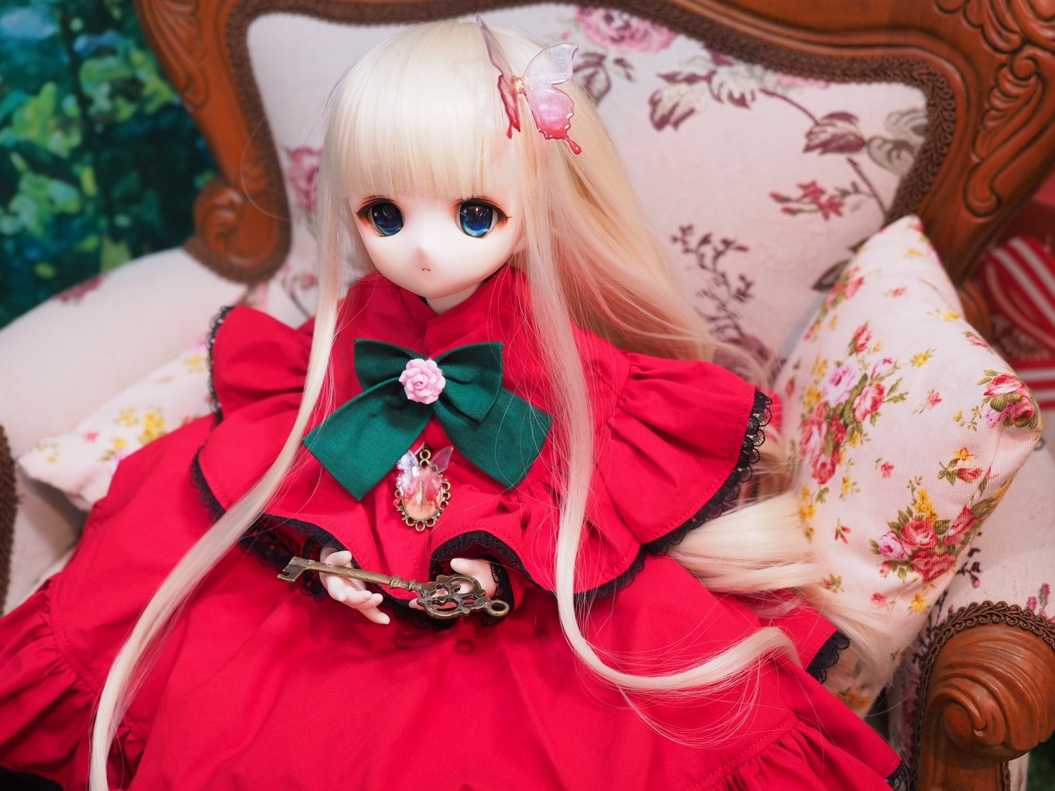 1girl blonde_hair blue_eyes bow capelet doll dress flower lace long_hair looking_at_viewer pink_flower red_capelet red_dress shinku sitting solo very_long_hair