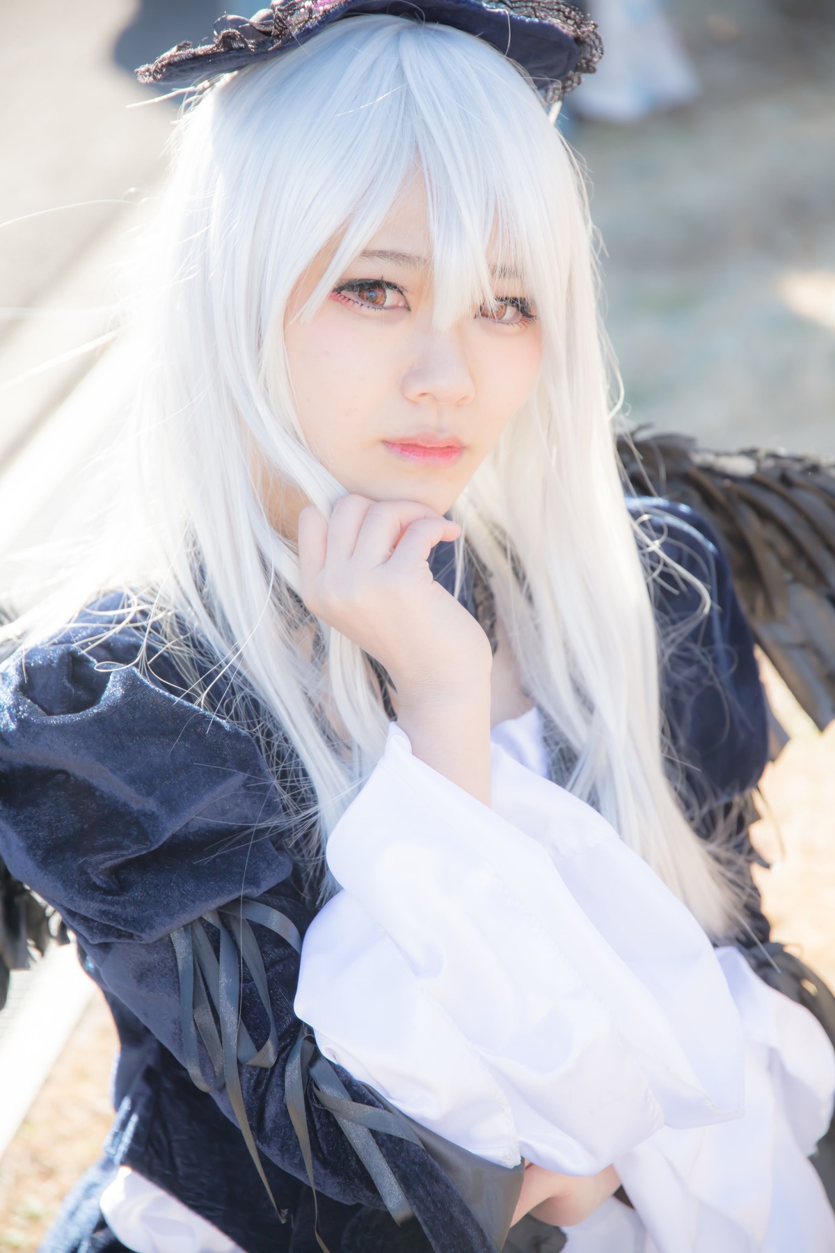 1girl blurry blurry_background blurry_foreground closed_mouth depth_of_field dress lips long_hair long_sleeves looking_at_viewer photo solo suigintou white_hair