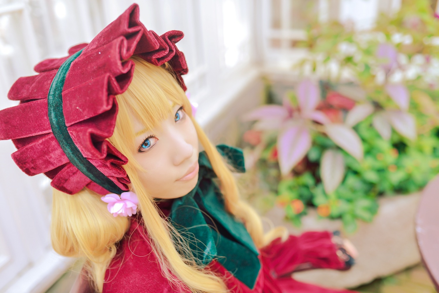 1girl bangs blonde_hair blue_eyes blurry blurry_background blurry_foreground bonnet closed_mouth depth_of_field flower long_hair looking_at_viewer shinku smile solo