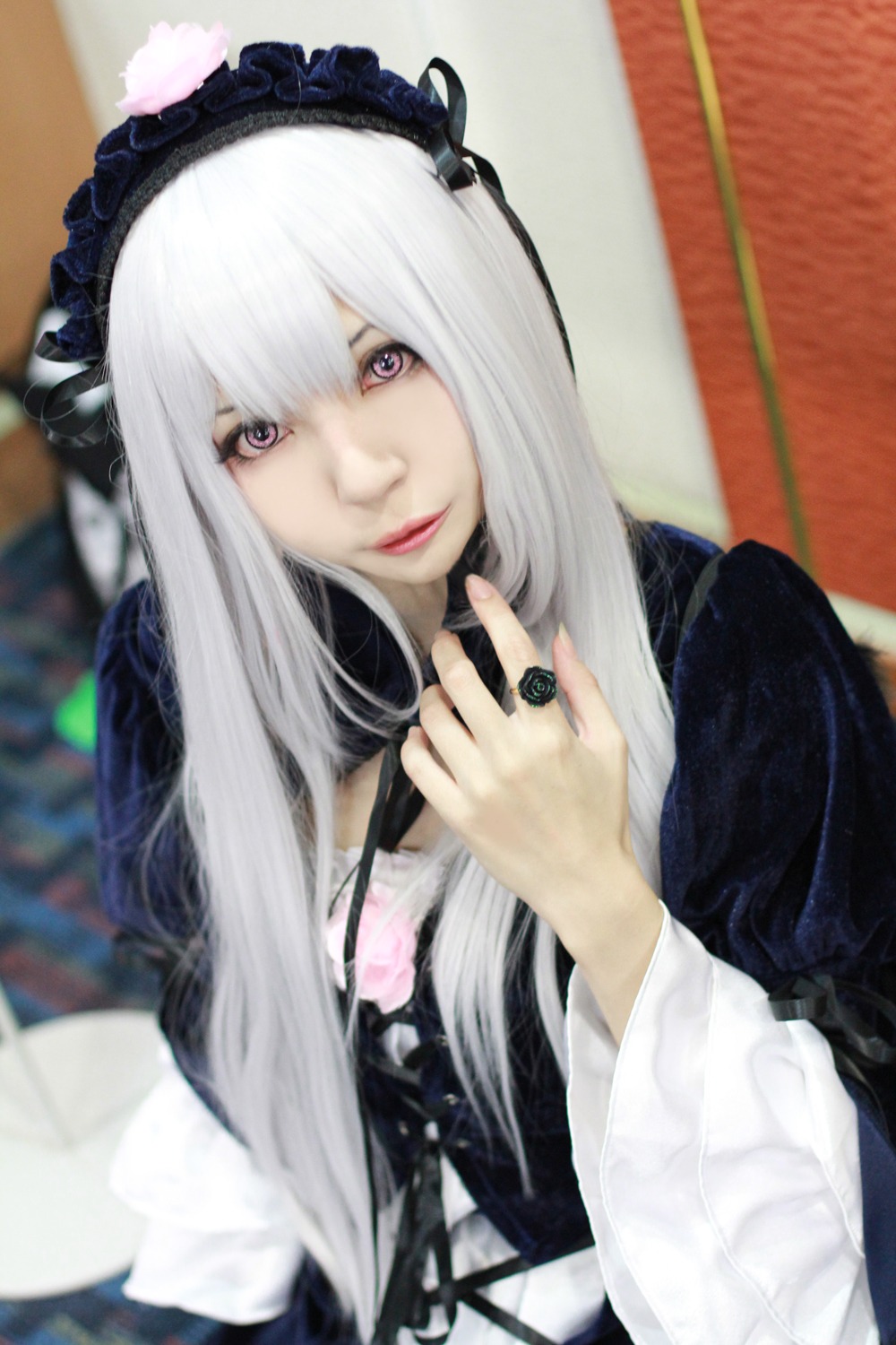 1girl bangs blurry blurry_background blurry_foreground closed_mouth depth_of_field hairband holding lips lolita_fashion long_hair long_sleeves looking_at_viewer photo purple_eyes solo suigintou upper_body