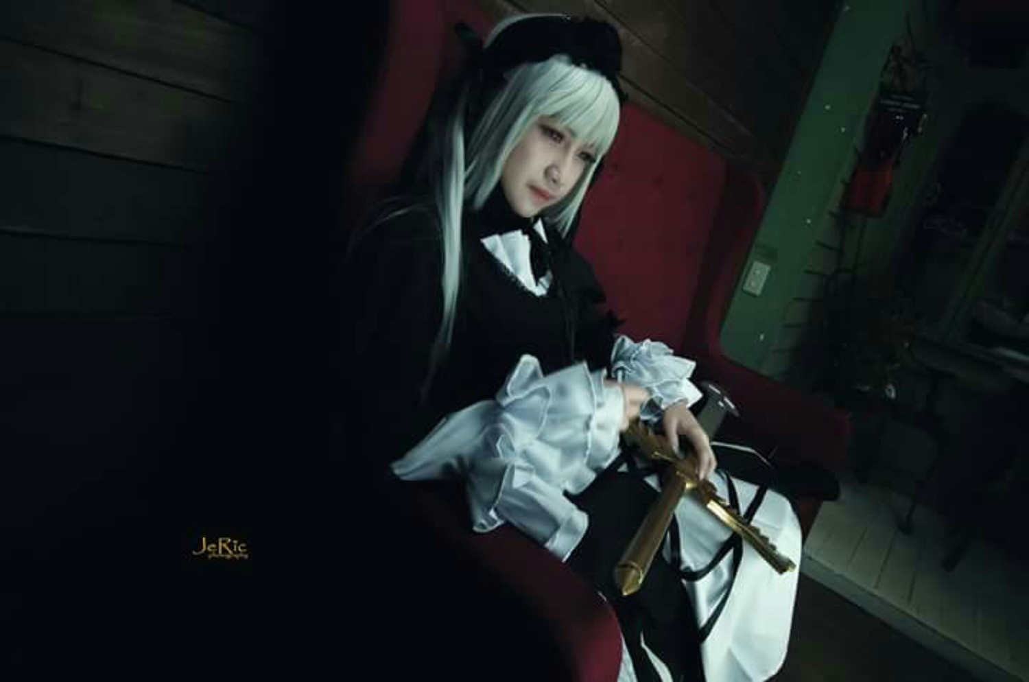 1girl bangs blunt_bangs dark dress frills hat indoors long_hair long_sleeves sitting solo suigintou