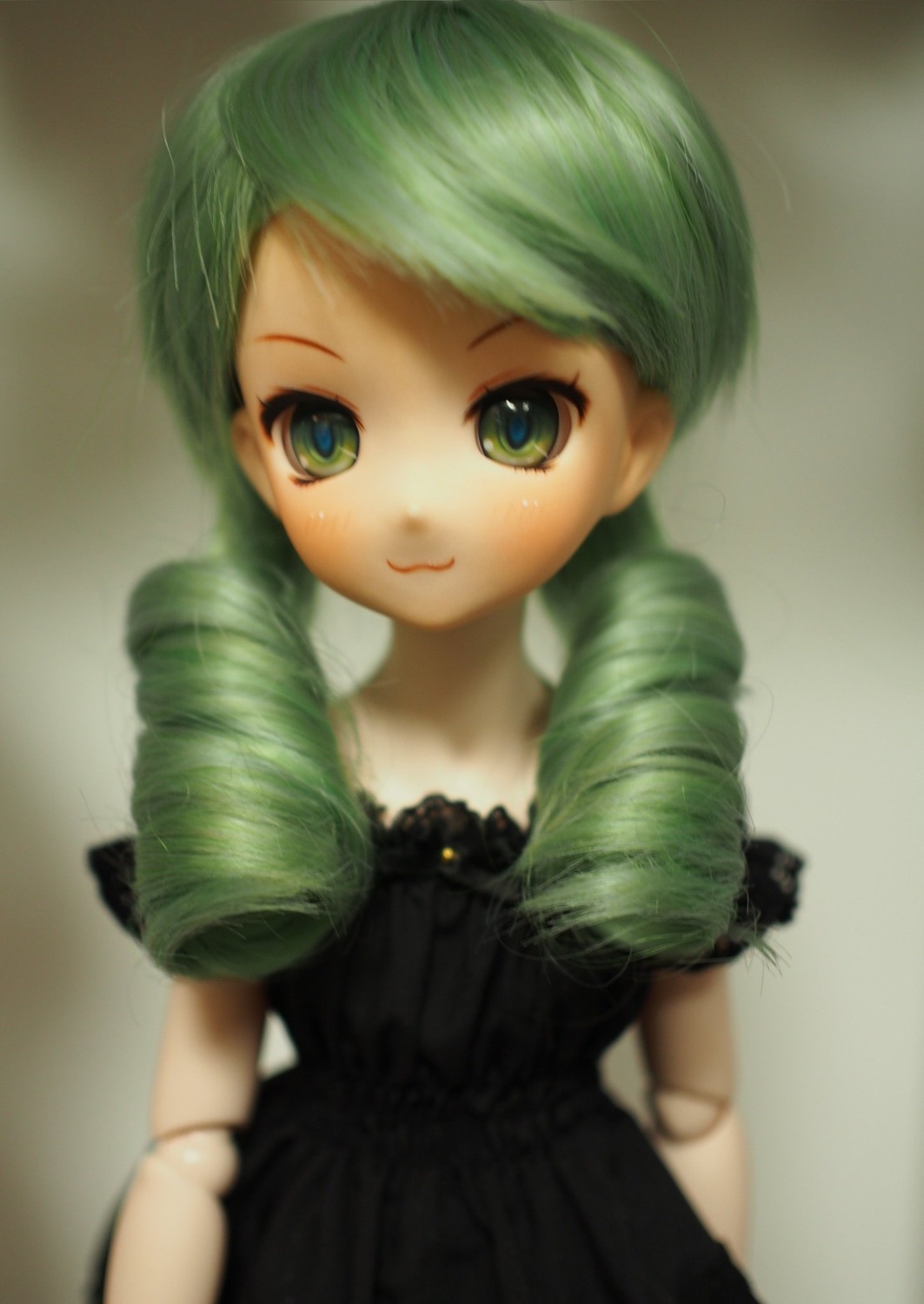 1girl black_dress blurry closed_mouth doll doll_joints dress drill_hair green_eyes green_hair joints kanaria long_hair looking_at_viewer ringlets smile solo twin_drills upper_body