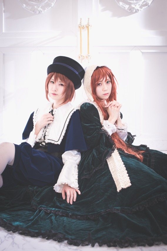 2girls back-to-back bangs brown_hair dress hand_on_own_chest hat lips long_sleeves looking_at_viewer multiple_cosplay multiple_girls red_hair short_hair siblings sisters sitting tagme twins