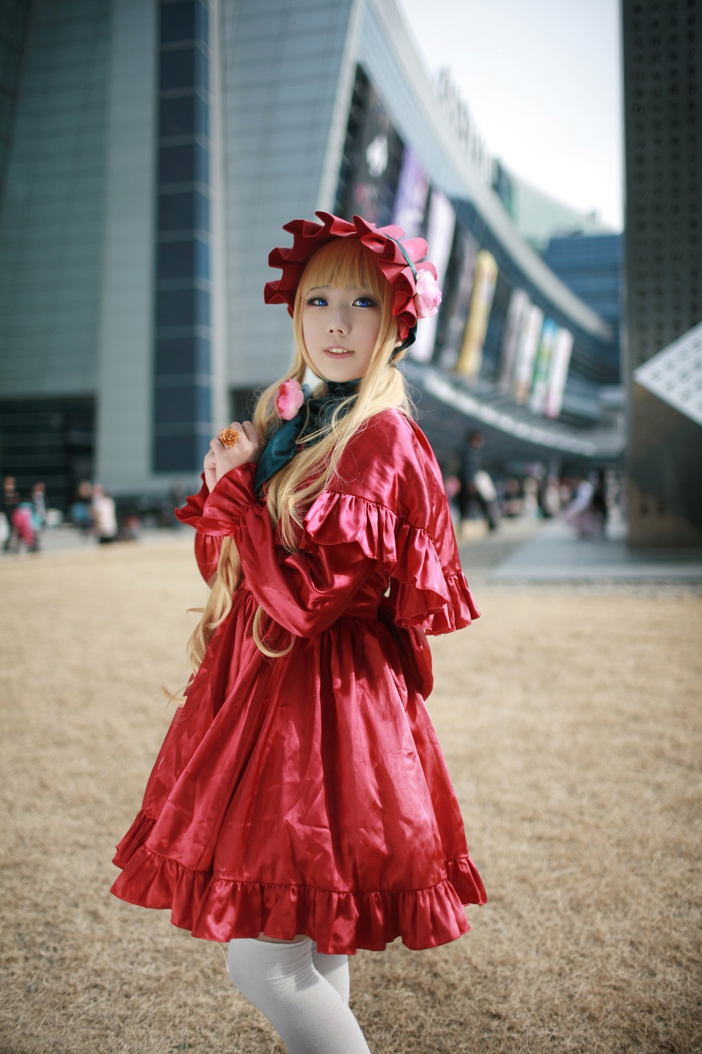 1girl blonde_hair blue_eyes blurry blurry_background bonnet building depth_of_field dress drill_hair figure frills long_hair outdoors pantyhose photo photo_background red_dress shinku solo standing