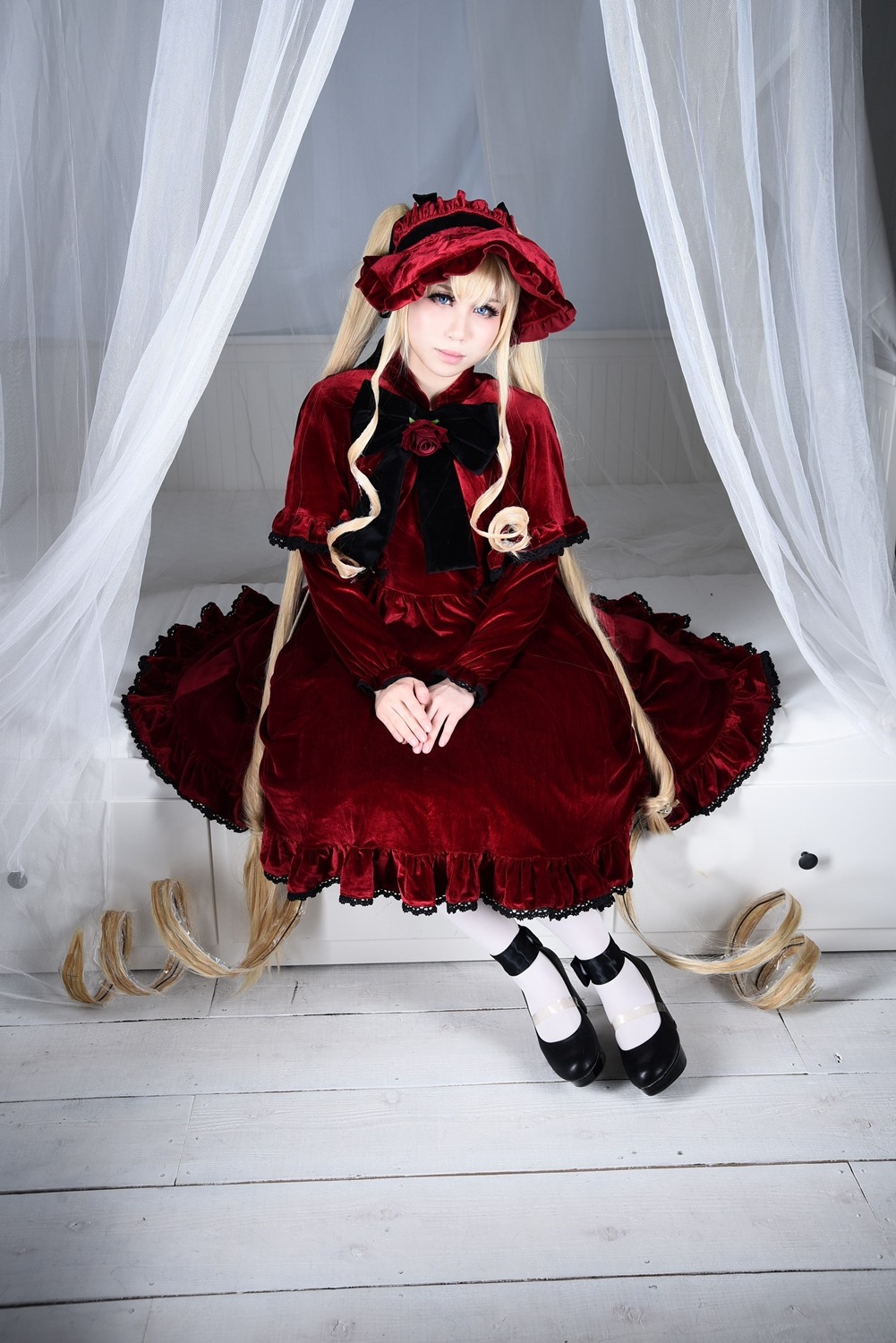 1girl black_footwear blonde_hair blue_eyes bonnet curtains dress flower lolita_fashion long_hair looking_at_viewer mary_janes pantyhose red_dress rose shinku shoes sitting solo twintails very_long_hair white_legwear