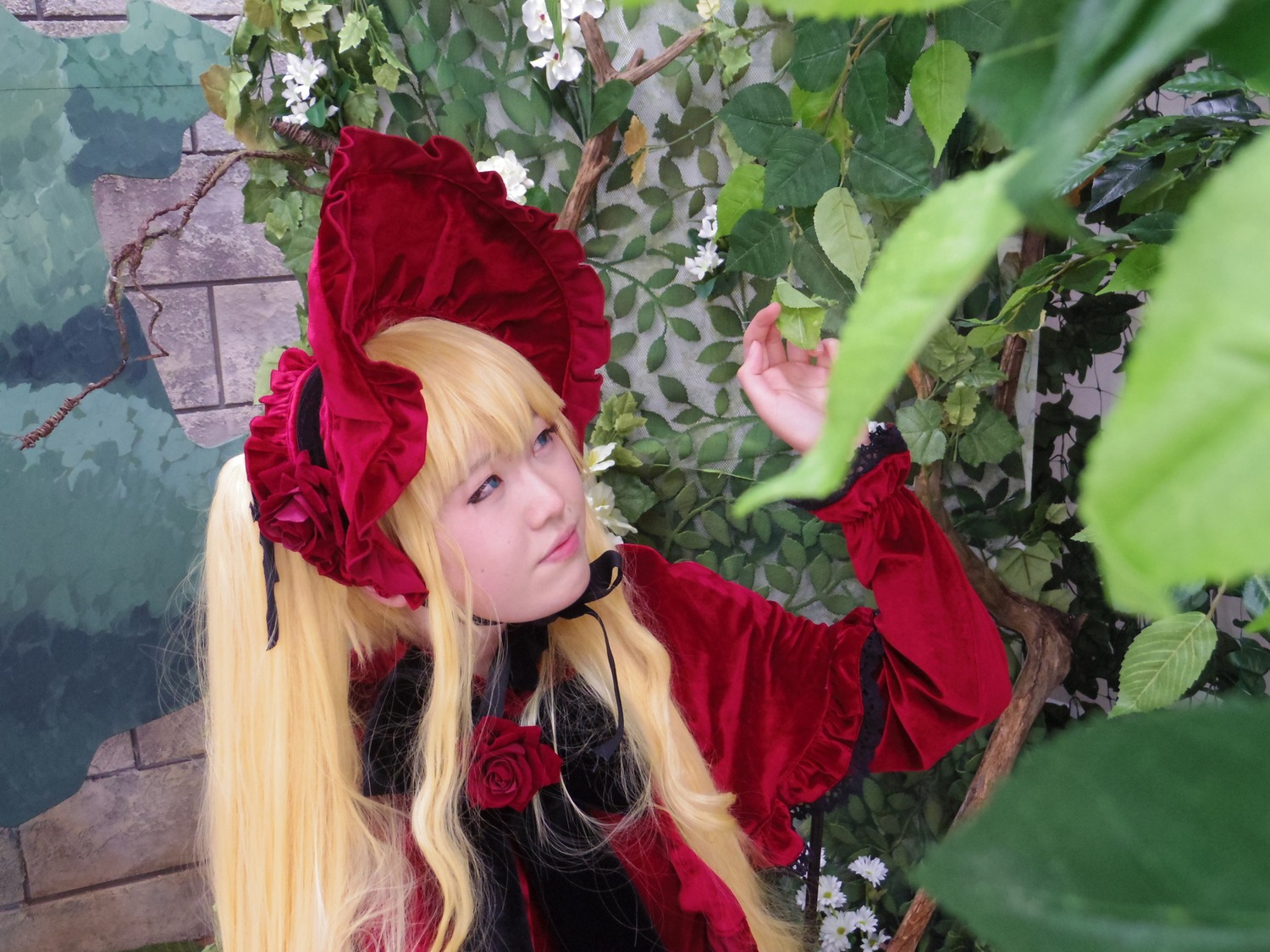 1girl blonde_hair blue_eyes bonnet bow dress flower lips long_hair long_sleeves outdoors realistic red_capelet red_dress rose shinku solo twintails