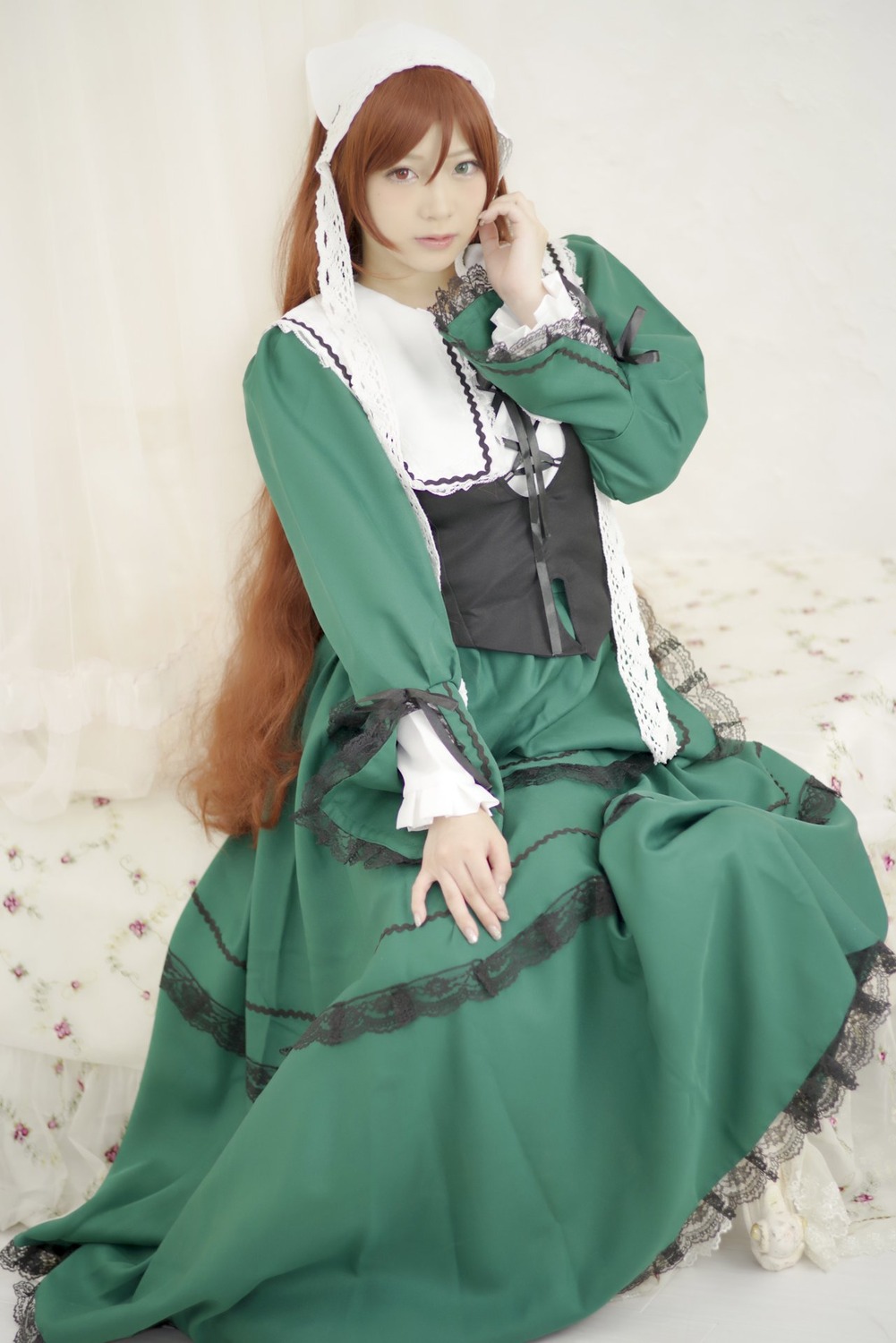 1girl brown_hair dress frills green_dress green_eyes heterochromia long_sleeves looking_at_viewer sitting solo suiseiseki