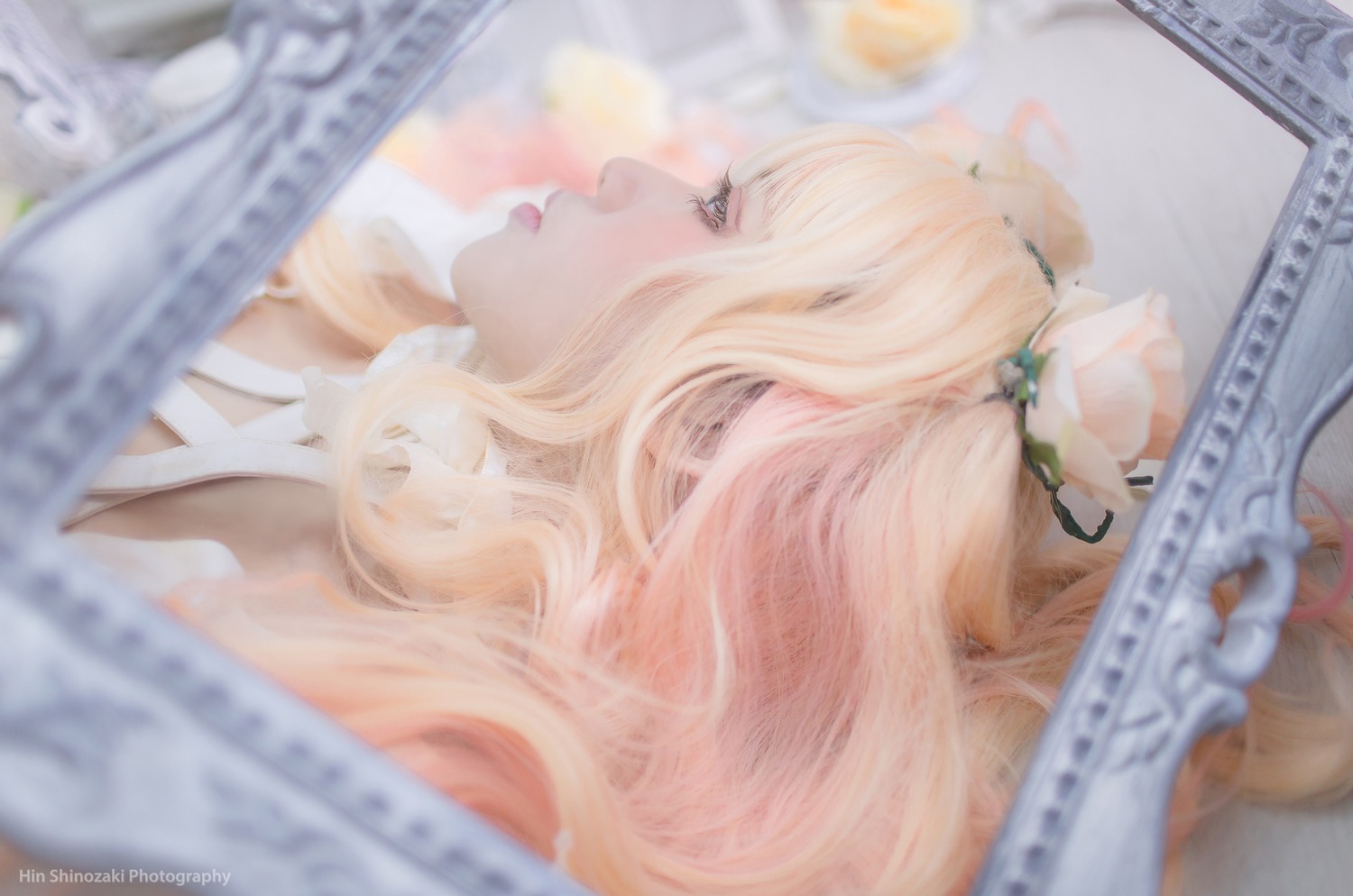 1girl artist_name bangs blonde_hair blue_eyes blurry blurry_background blurry_foreground depth_of_field hair_flower hair_ornament instrument kirakishou lips long_hair motion_blur newspaper parted_lips photo profile sheet_music solo watermark web_address white_flower