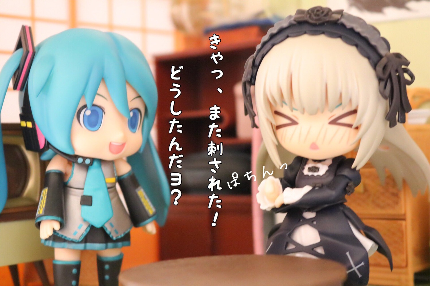 2girls >_< blonde_hair blurry chibi closed_eyes crossover depth_of_field doll food hairband hatsune_miku lolita_hairband long_hair long_sleeves multiple_girls solo suigintou table thighhighs twintails wings