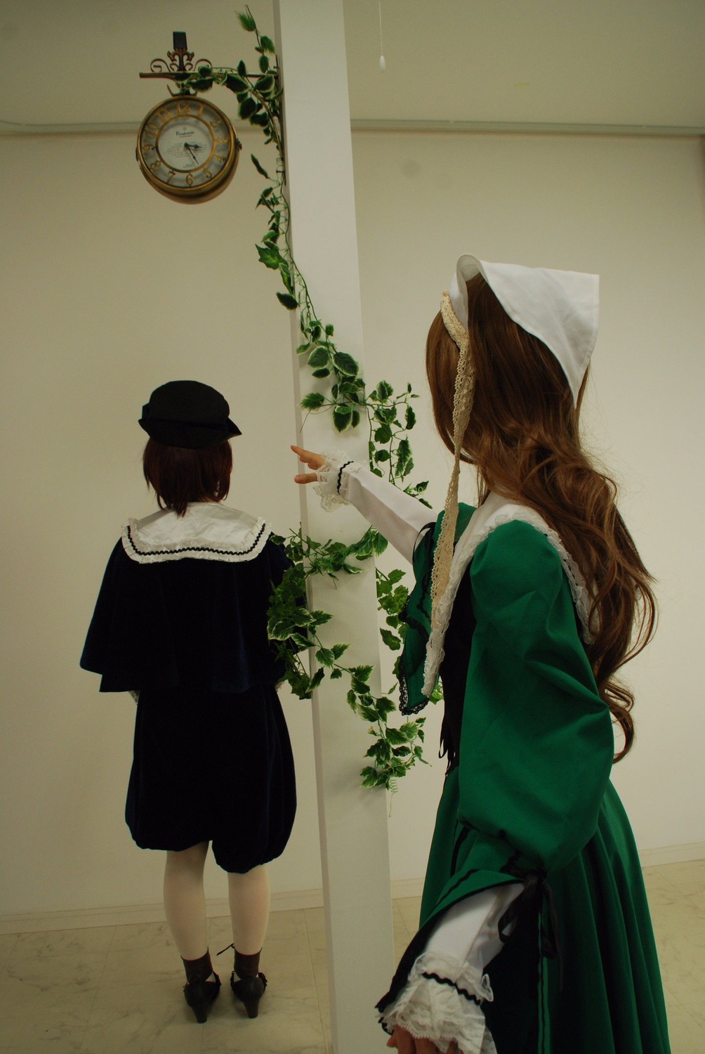 2girls brown_hair dress flower green_dress hat indoors long_hair long_sleeves multiple_cosplay multiple_girls plant standing tagme