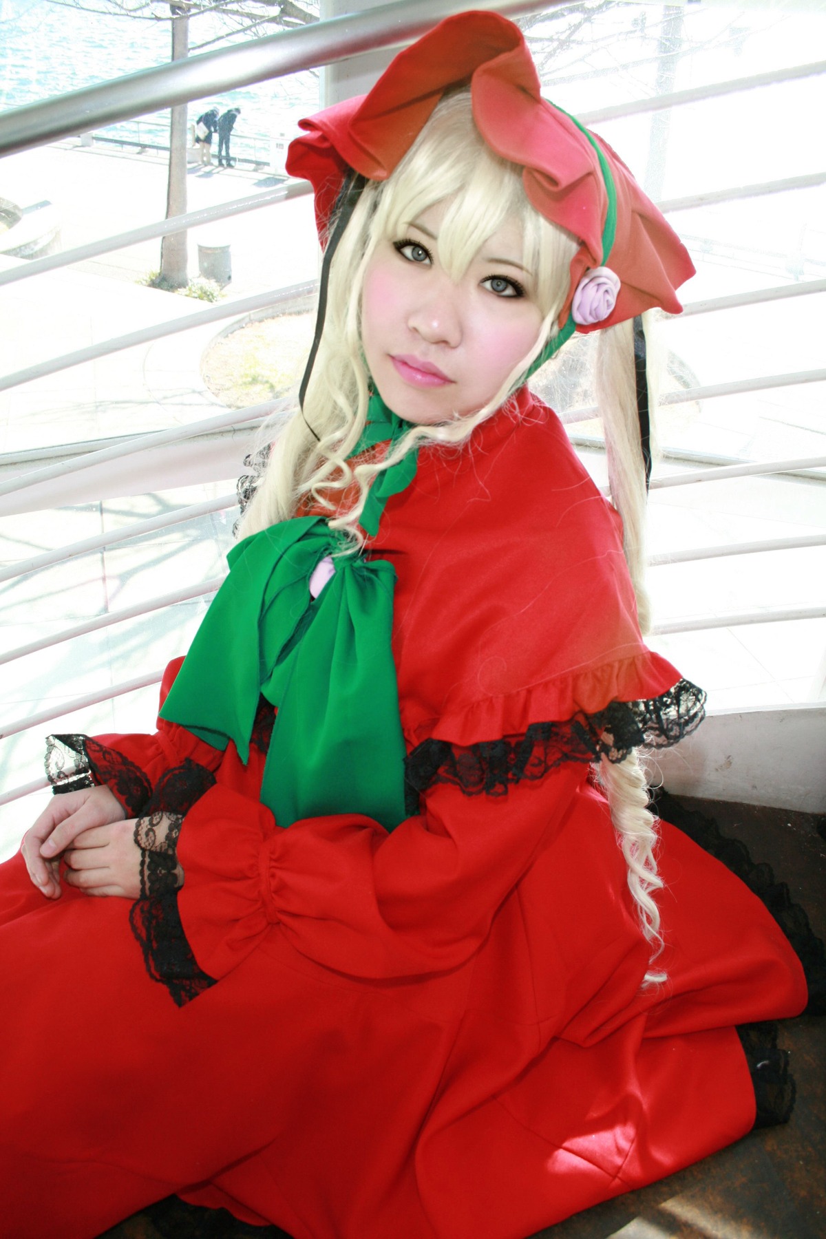 1girl blonde_hair bonnet bow capelet dress flower hat long_sleeves looking_at_viewer red_dress shinku sitting solo