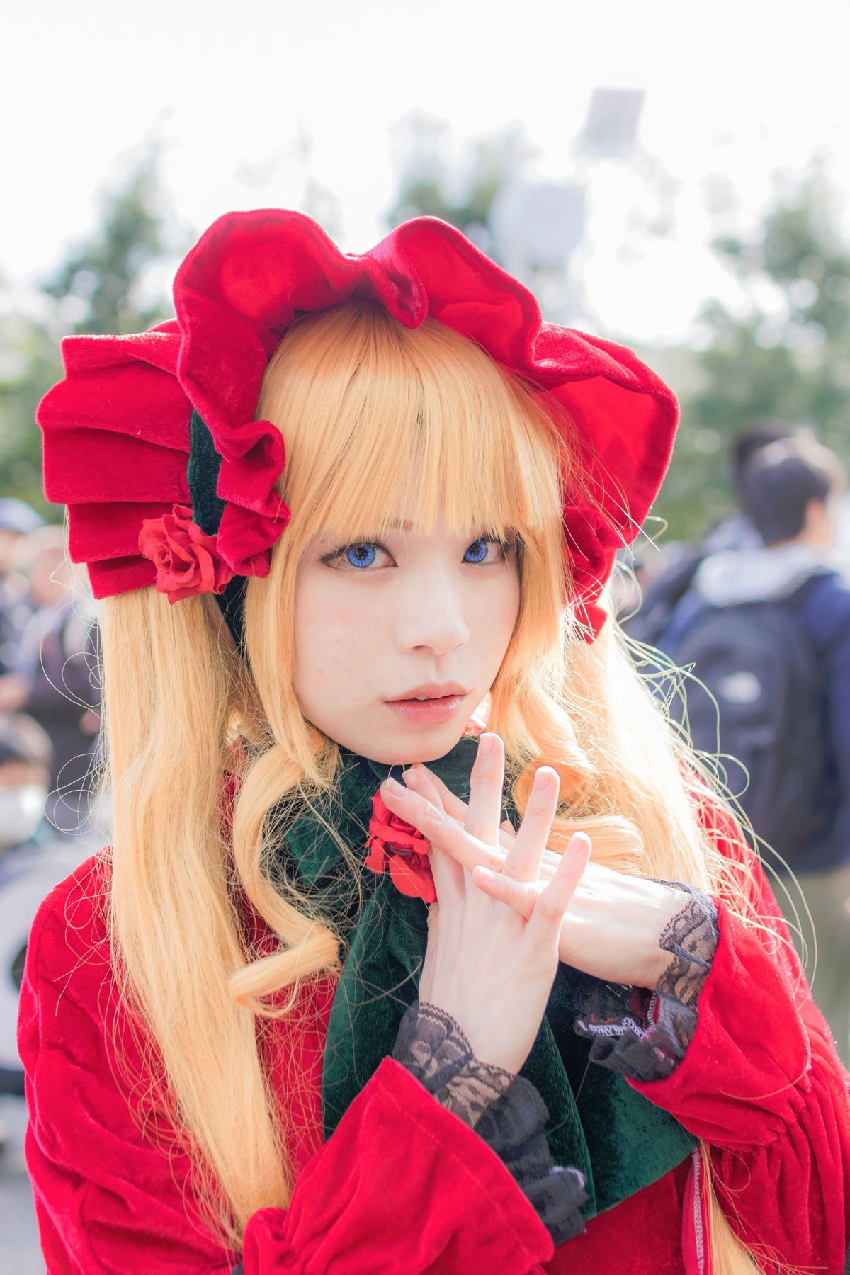 1girl blonde_hair blue_eyes blurry blurry_background blurry_foreground bonnet depth_of_field dress flower hat lips long_hair looking_at_viewer photo realistic red_dress shinku solo solo_focus upper_body