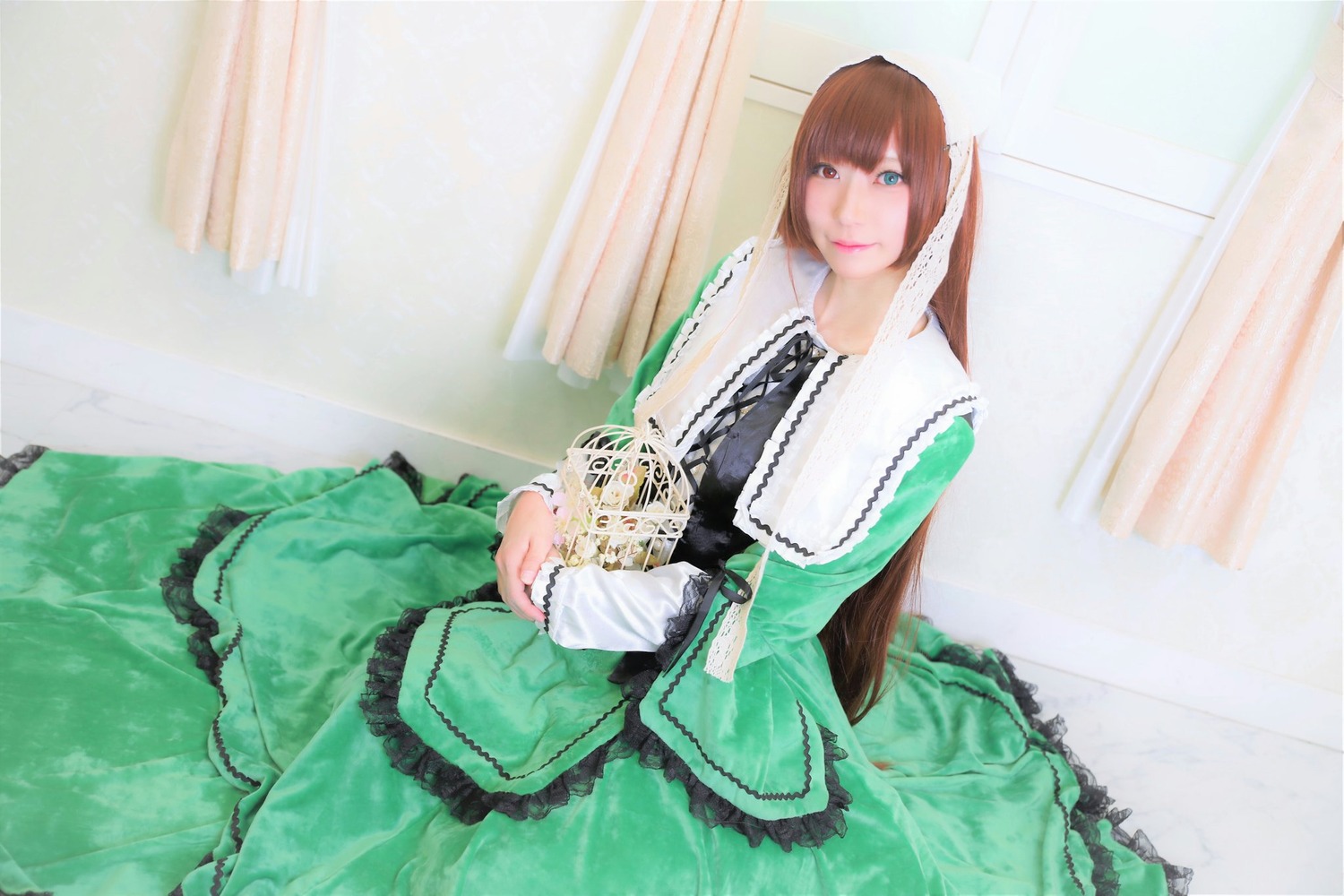 1girl bangs blue_eyes brown_hair curtains dress frills green_dress indoors lace long_hair long_sleeves looking_at_viewer sitting solo suiseiseki