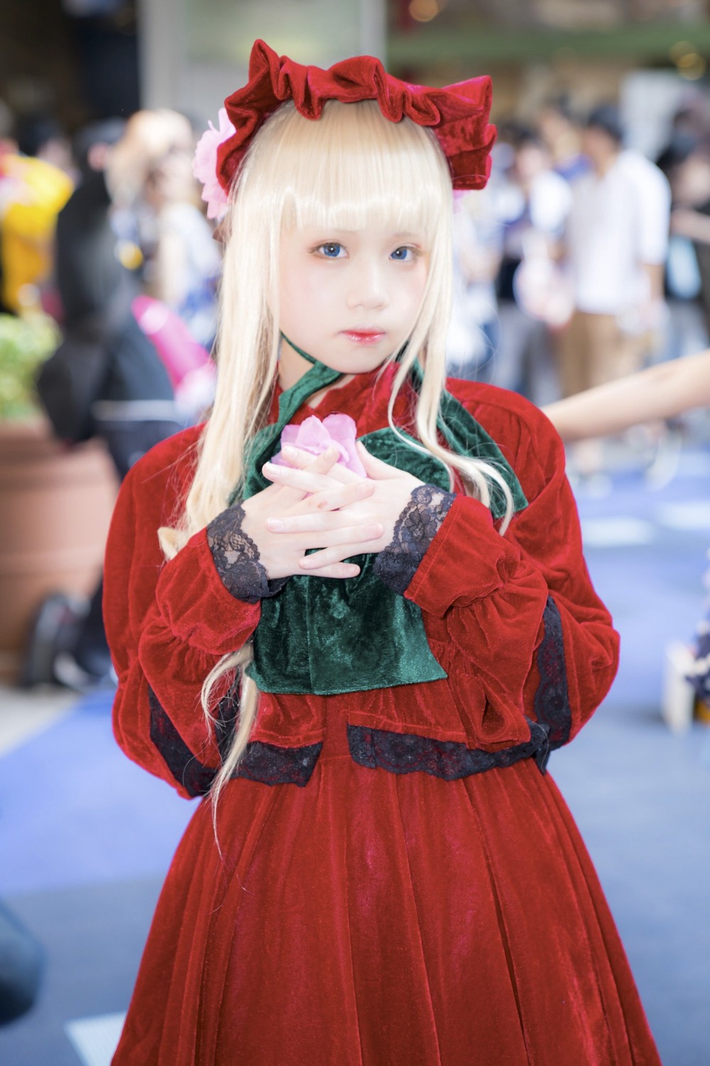 1girl bangs blonde_hair blue_eyes blurry blurry_background blurry_foreground coat depth_of_field dress figure lips long_hair long_sleeves looking_at_viewer outdoors photo red_dress shinku solo standing