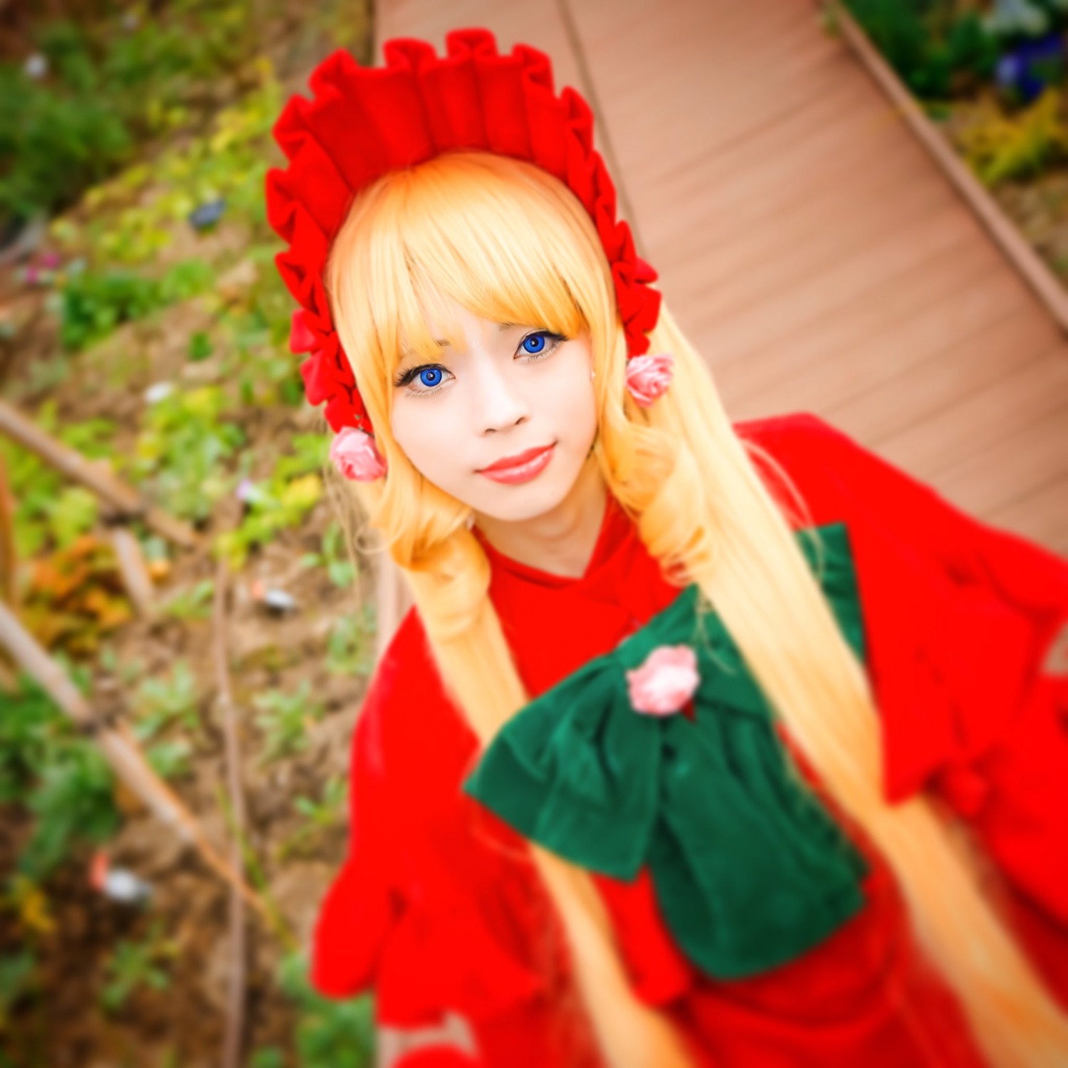 1girl blonde_hair blue_eyes blurry blurry_background blurry_foreground bonnet depth_of_field flower lips long_hair looking_at_viewer photo shinku smile solo