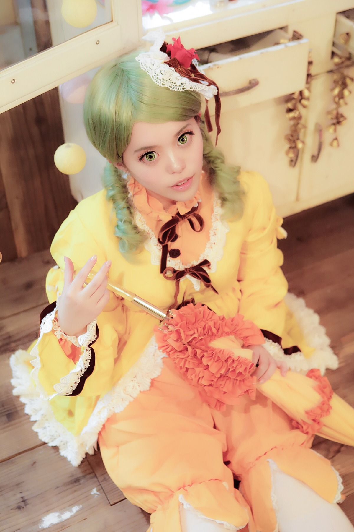 1girl blurry depth_of_field dress flower frills green_eyes green_hair hair_flower hair_ornament kanaria lips looking_at_viewer realistic ribbon sitting smile solo yellow_dress