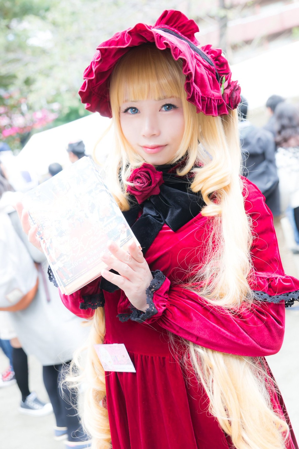 1girl bangs blonde_hair blue_eyes blurry blurry_background blurry_foreground bonnet depth_of_field dress figure flower lips looking_at_viewer photo pink_flower pink_rose red_dress red_flower red_rose rose shinku solo solo_focus